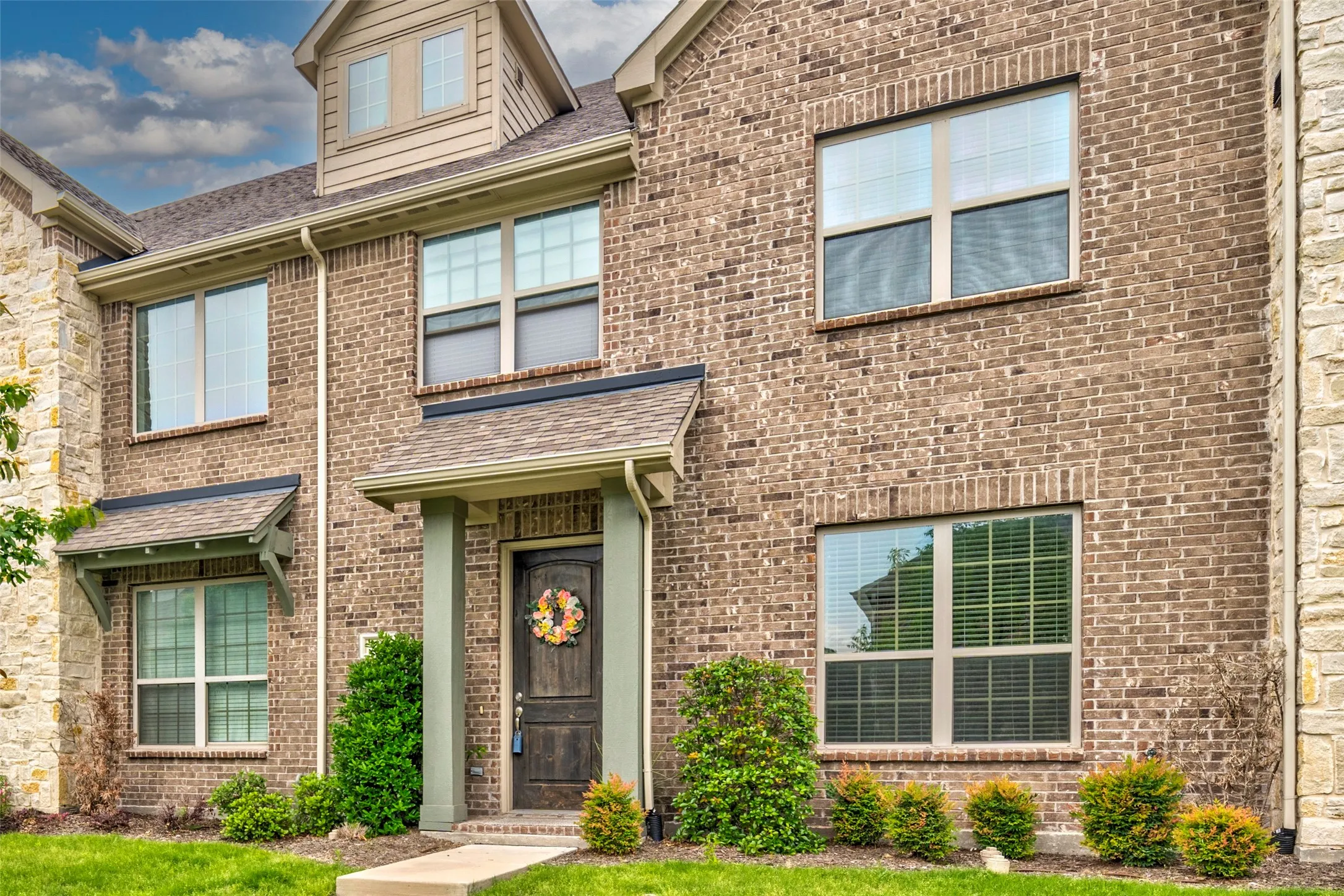 Brick and stone facade featuring multiple windows