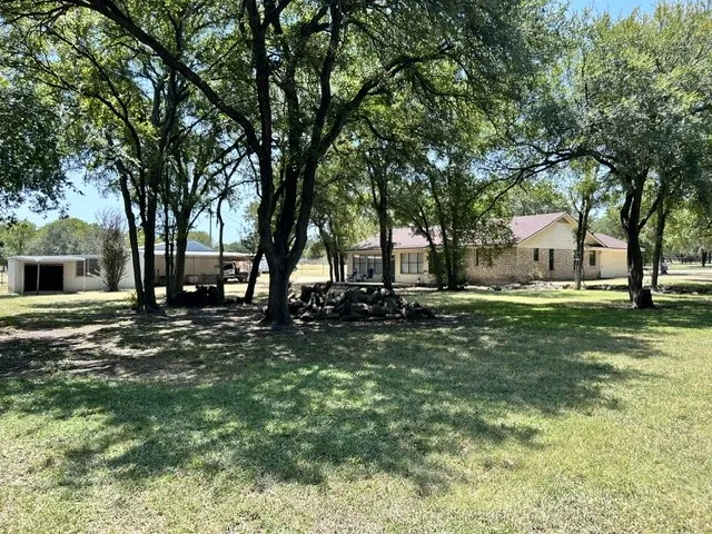 It is 100 degrees outside and I did not care with all these shade trees.  This is the beautiful back yard looking at the back yard with the open deck and a side view of the shop and equipment shed area.