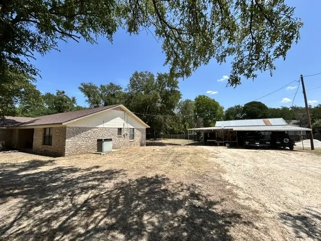 Side view of home and part of the driveway that leads to the shop with additional covered parking.