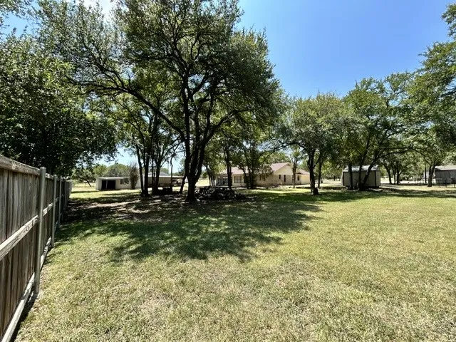 Back yard view of the house and shop, equipment shed area and the other small shed on the two car garage side of the house.