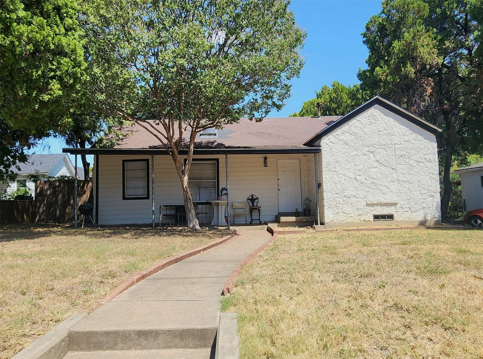 Single-story exterior with white siding and textured stucco finish