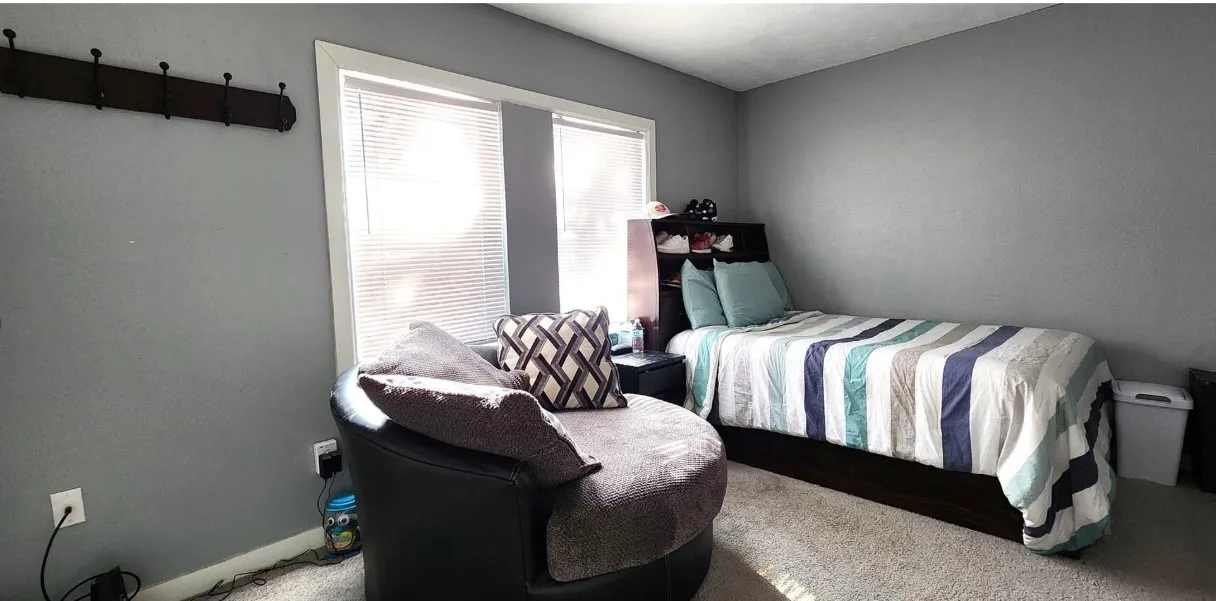Recessed window with white trim, built-in wall-mounted coat rack, light gray wall color, and wall-to-wall carpeting