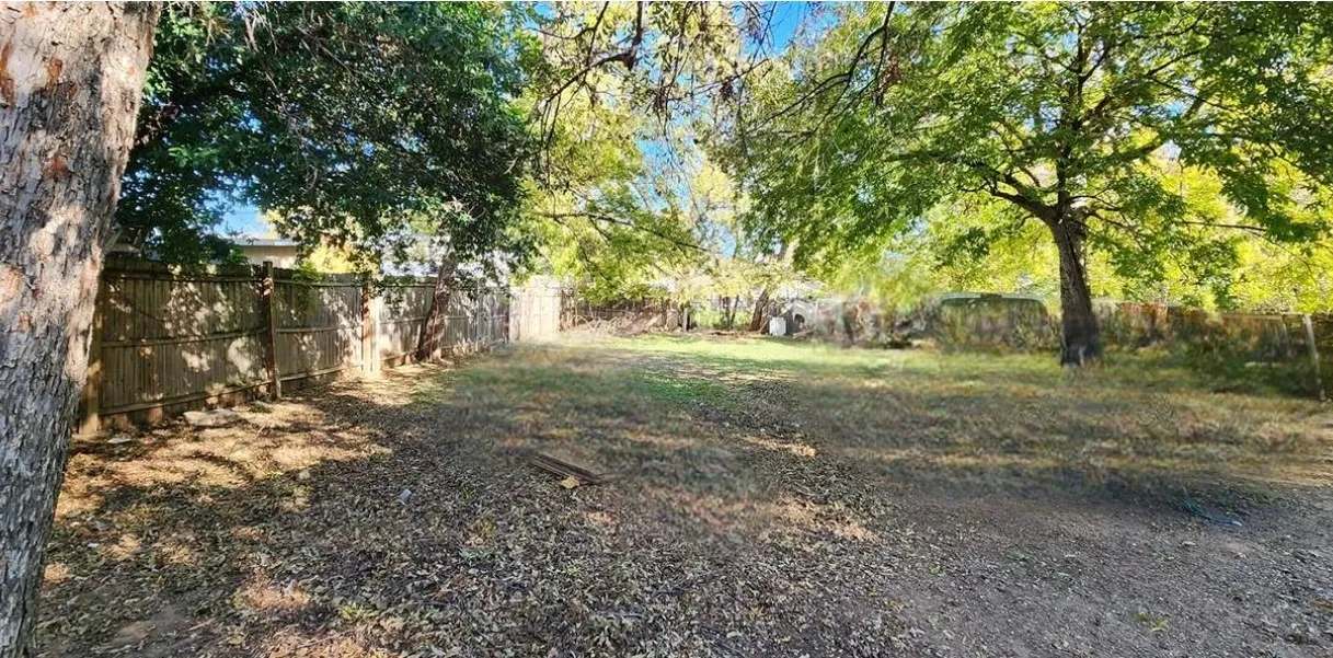 Expansive lot featuring mature trees and perimeter fencing