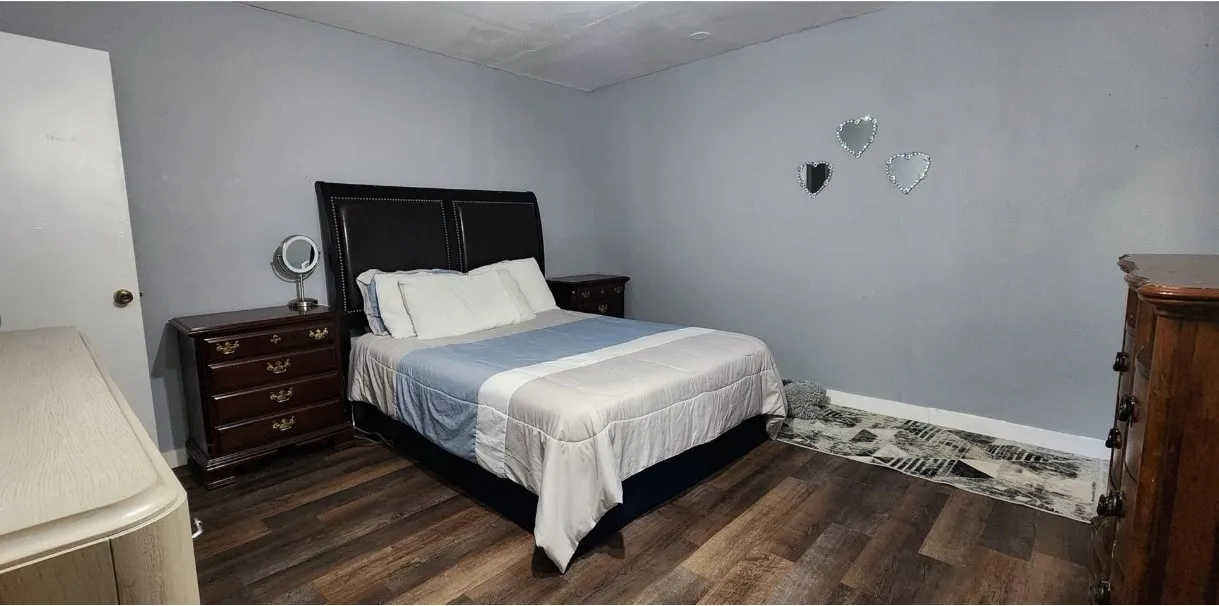 Wood-finish flooring with light gray walls and a white door