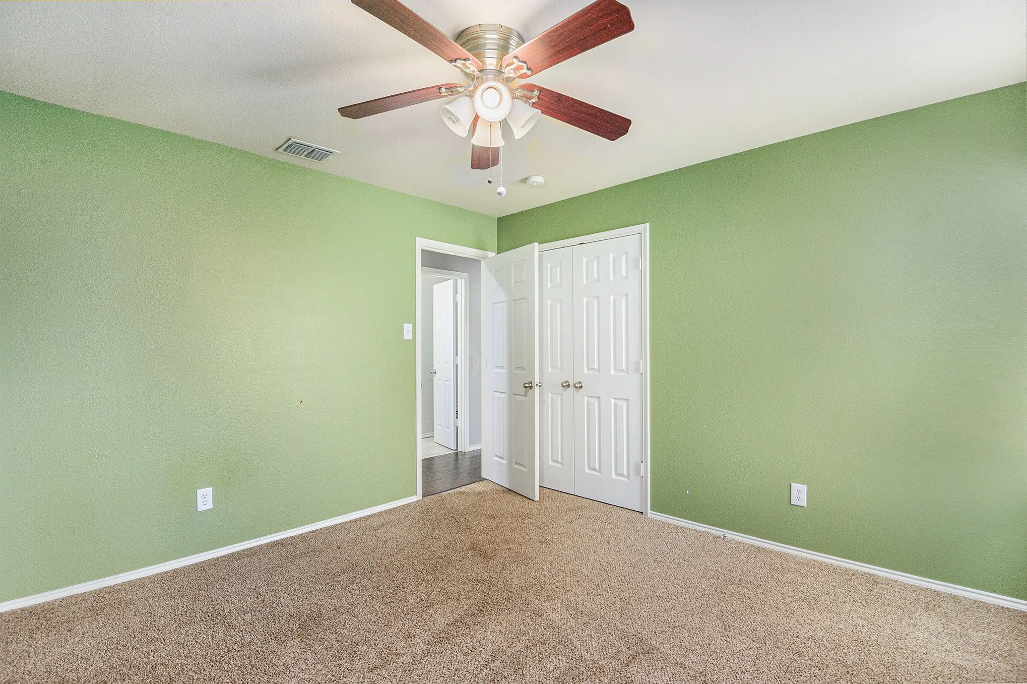 Unfurnished bedroom featuring carpet floors, ceiling fan, and a closet