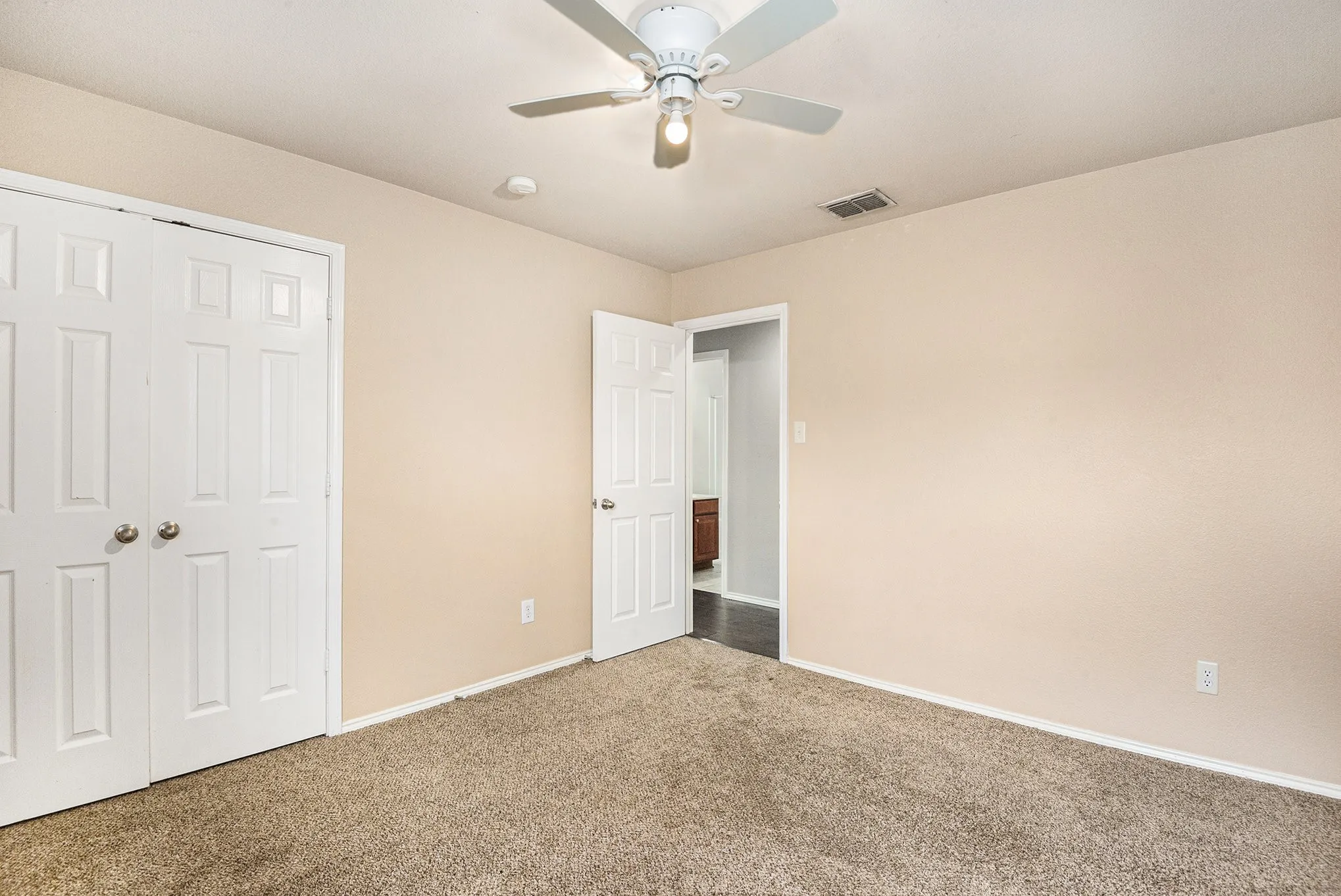 Unfurnished bedroom featuring carpet, a closet, and a ceiling fan