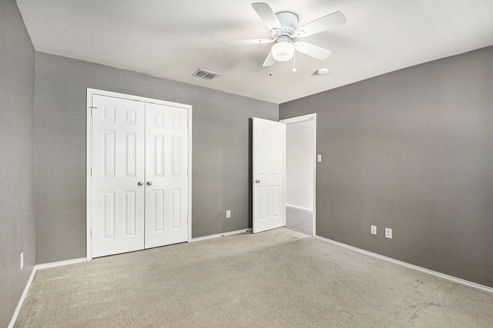 Unfurnished bedroom with carpet floors, a ceiling fan, and a closet