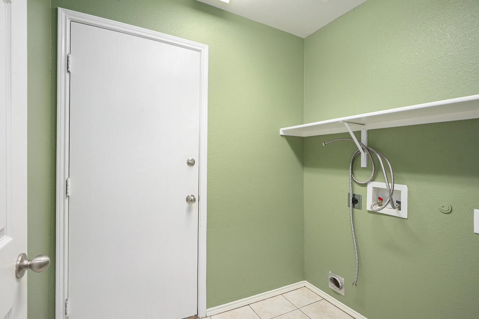 Laundry area featuring hookup for a washing machine, electric dryer hookup, and light tile patterned floors