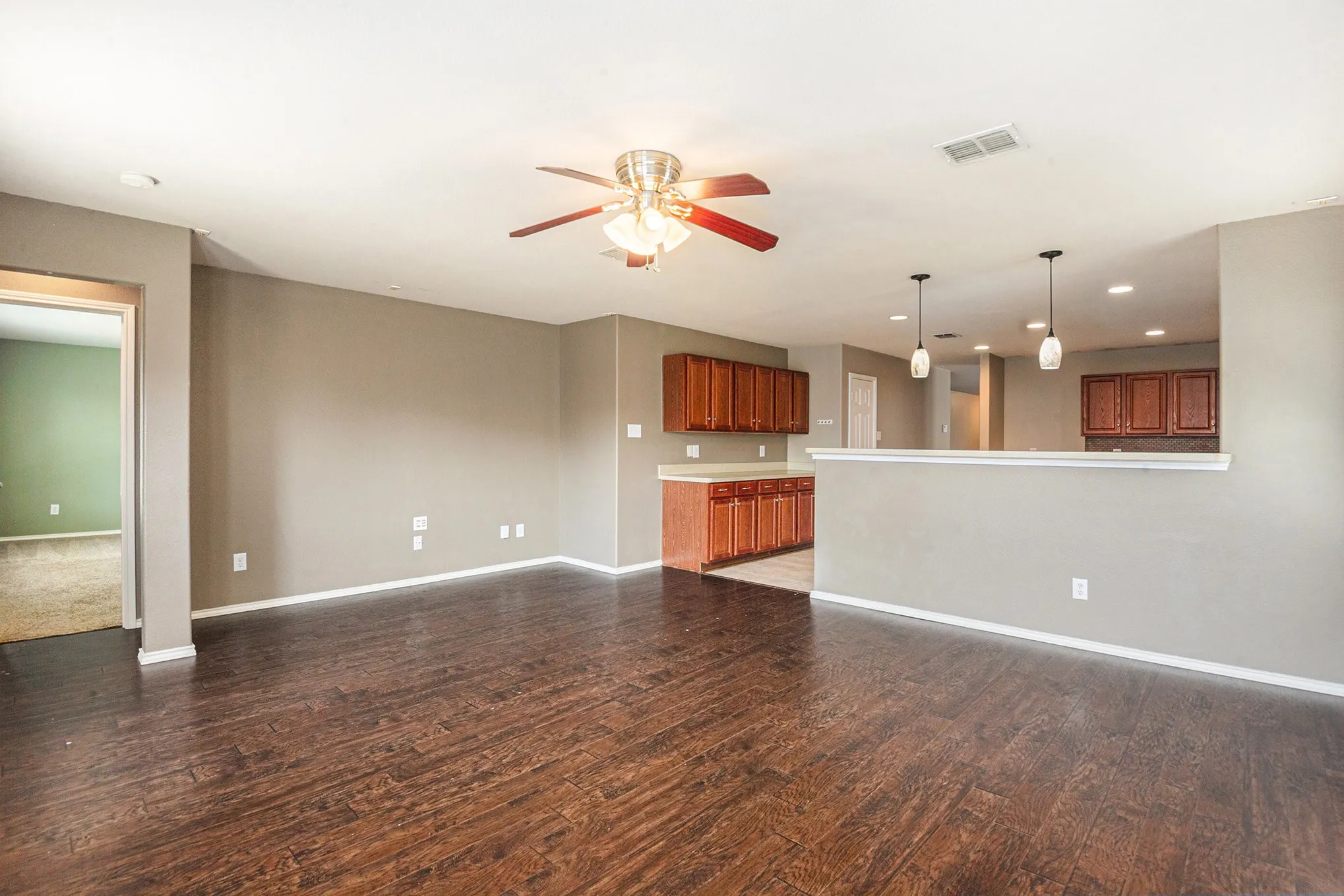 Unfurnished living room featuring a ceiling fan, recessed lighting, and dark wood finished floors