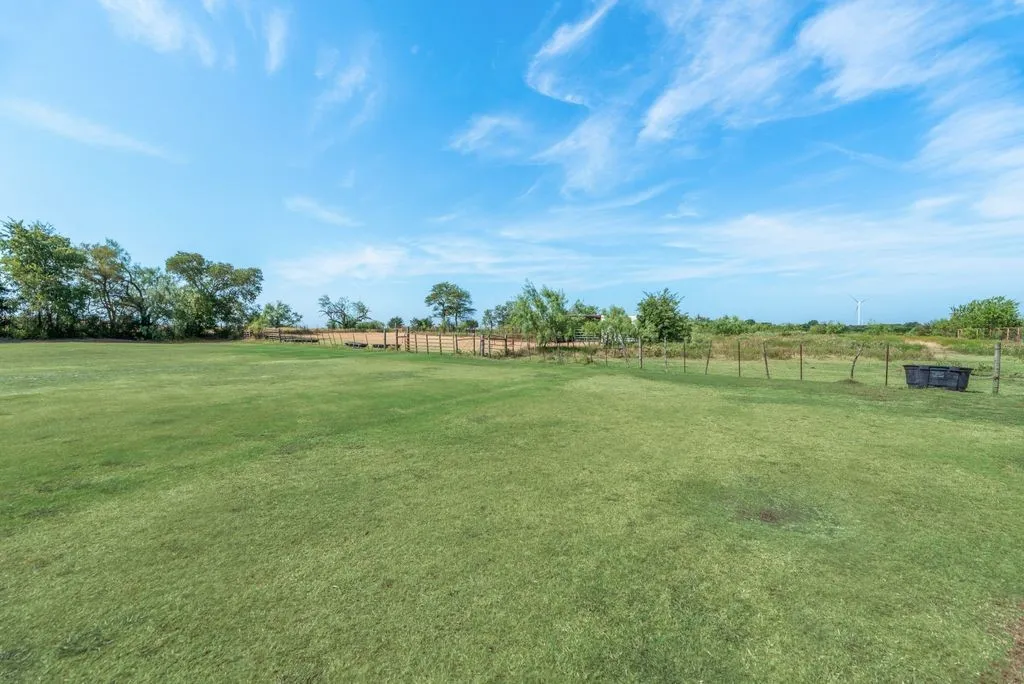 Expansive grass lawn with perimeter fencing