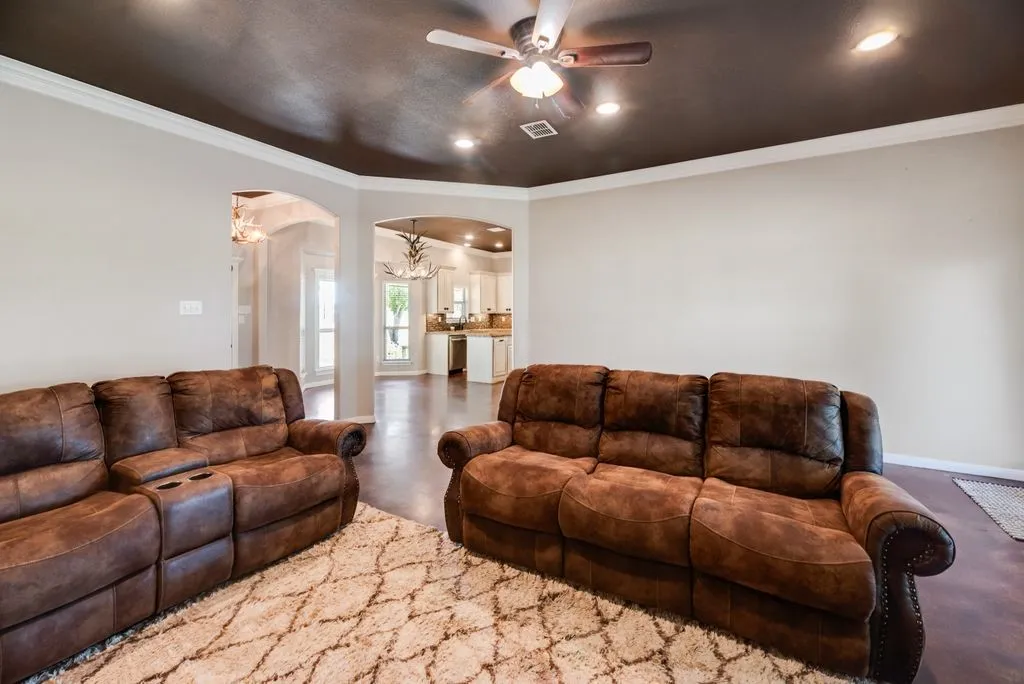 Recessed lighting, ceiling fan, crown molding, arched doorways, and wood-finish flooring