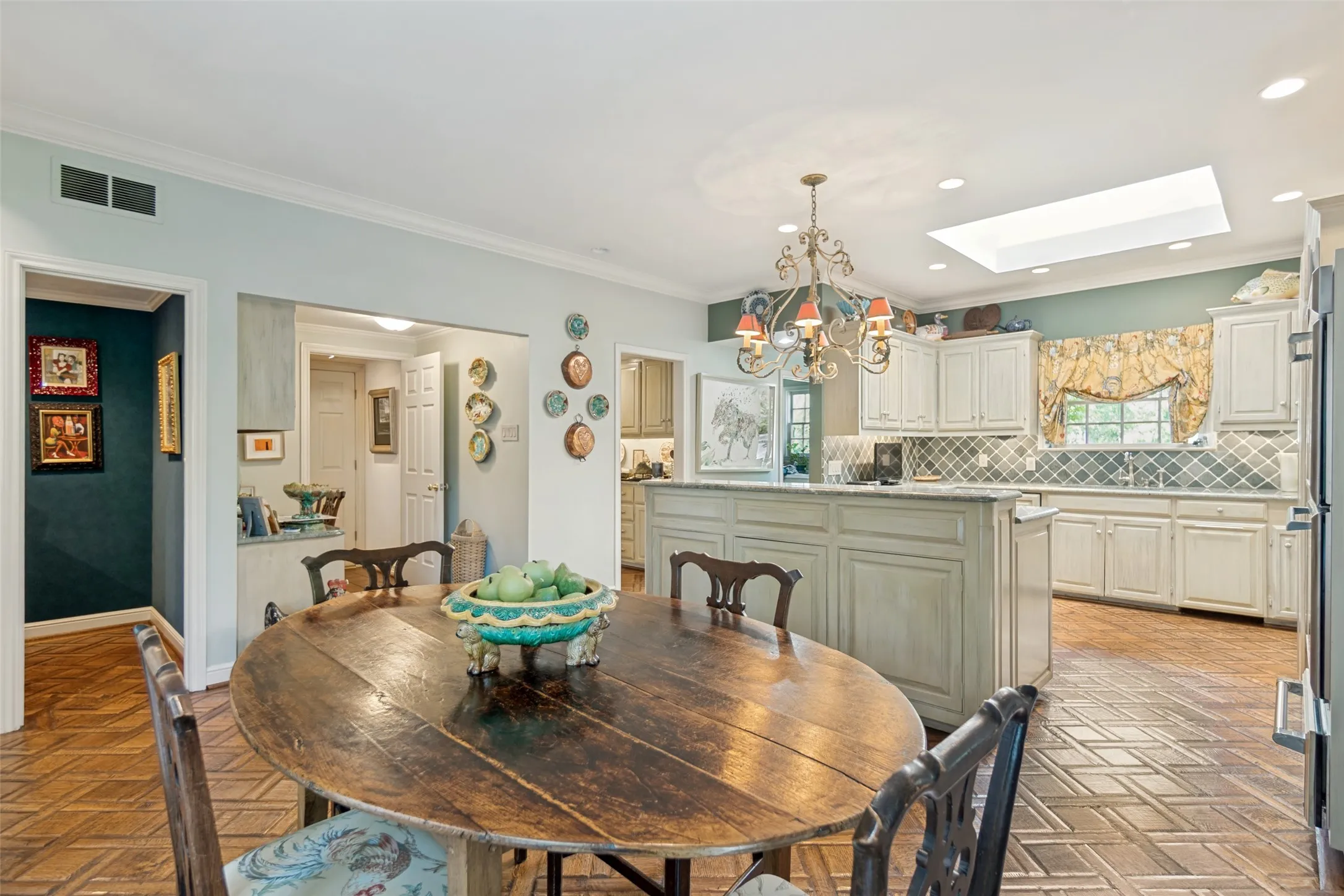 Kitchen featuring a center island, white cabinetry, decorative tile backsplash, recessed lighting, and a skylight