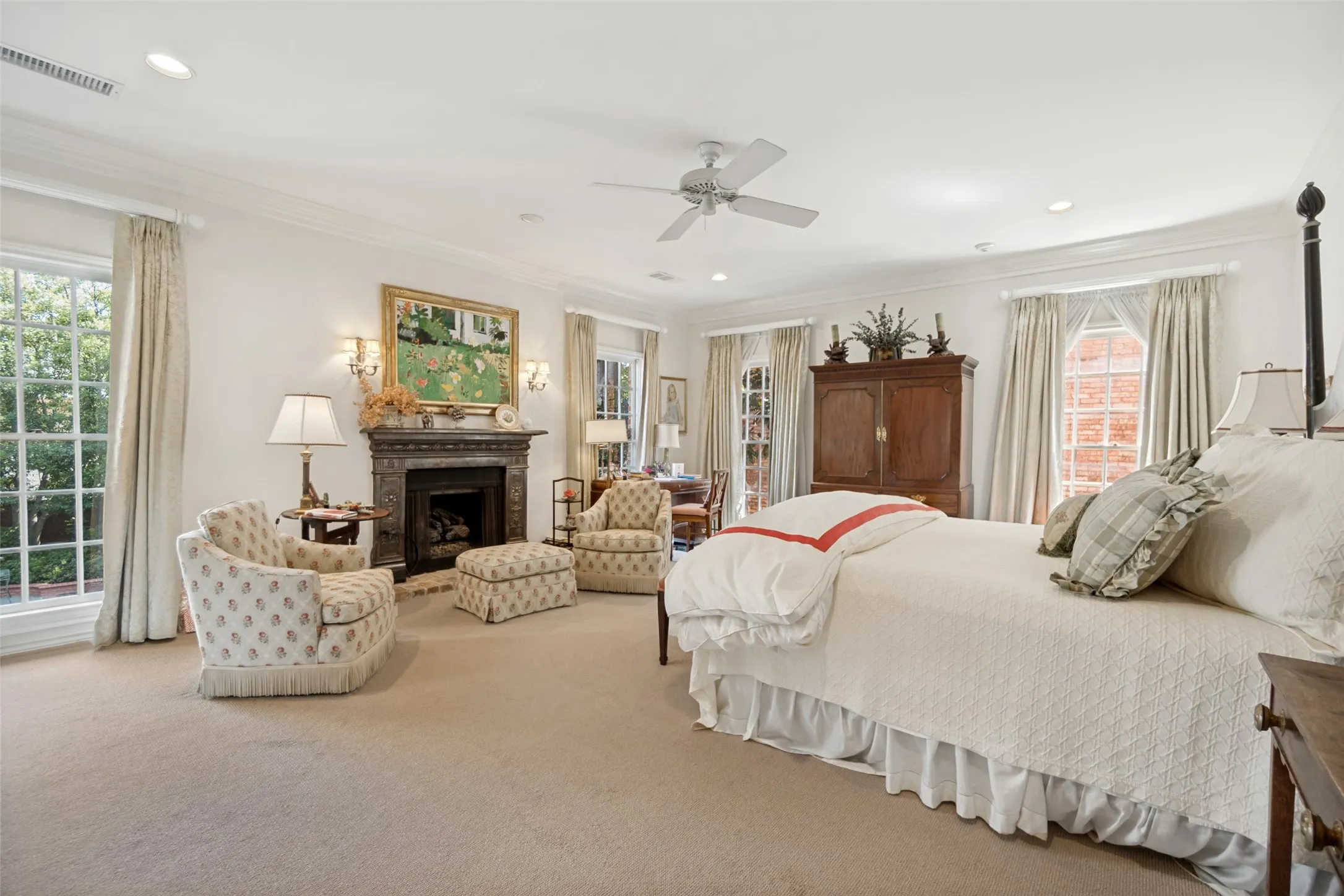 Recessed lighting, crown molding, ceiling fan, decorative fireplace with stone mantel, and large windows