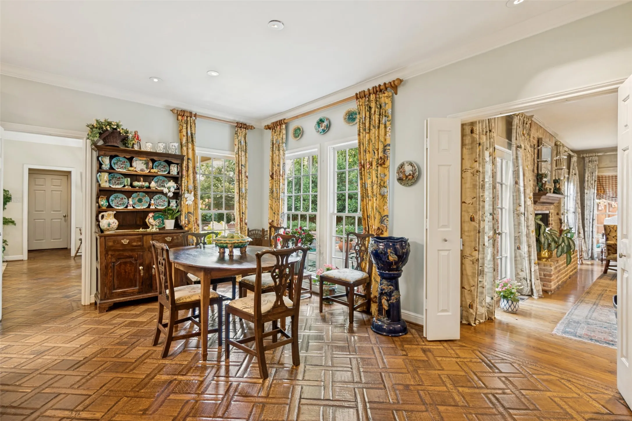 Wood-finish parquet flooring, multiple windows, double doors, recessed lighting, and a wide cased opening