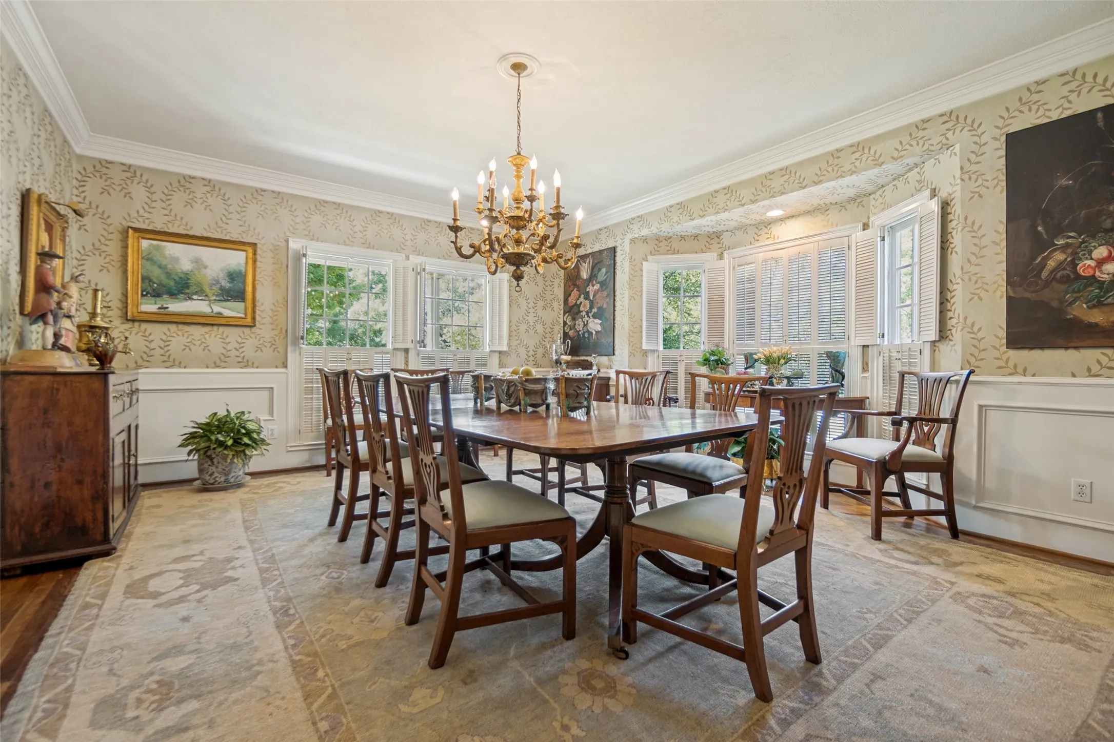 Crown molding, chandelier lighting, wainscoting, bay window, and hardwood flooring
