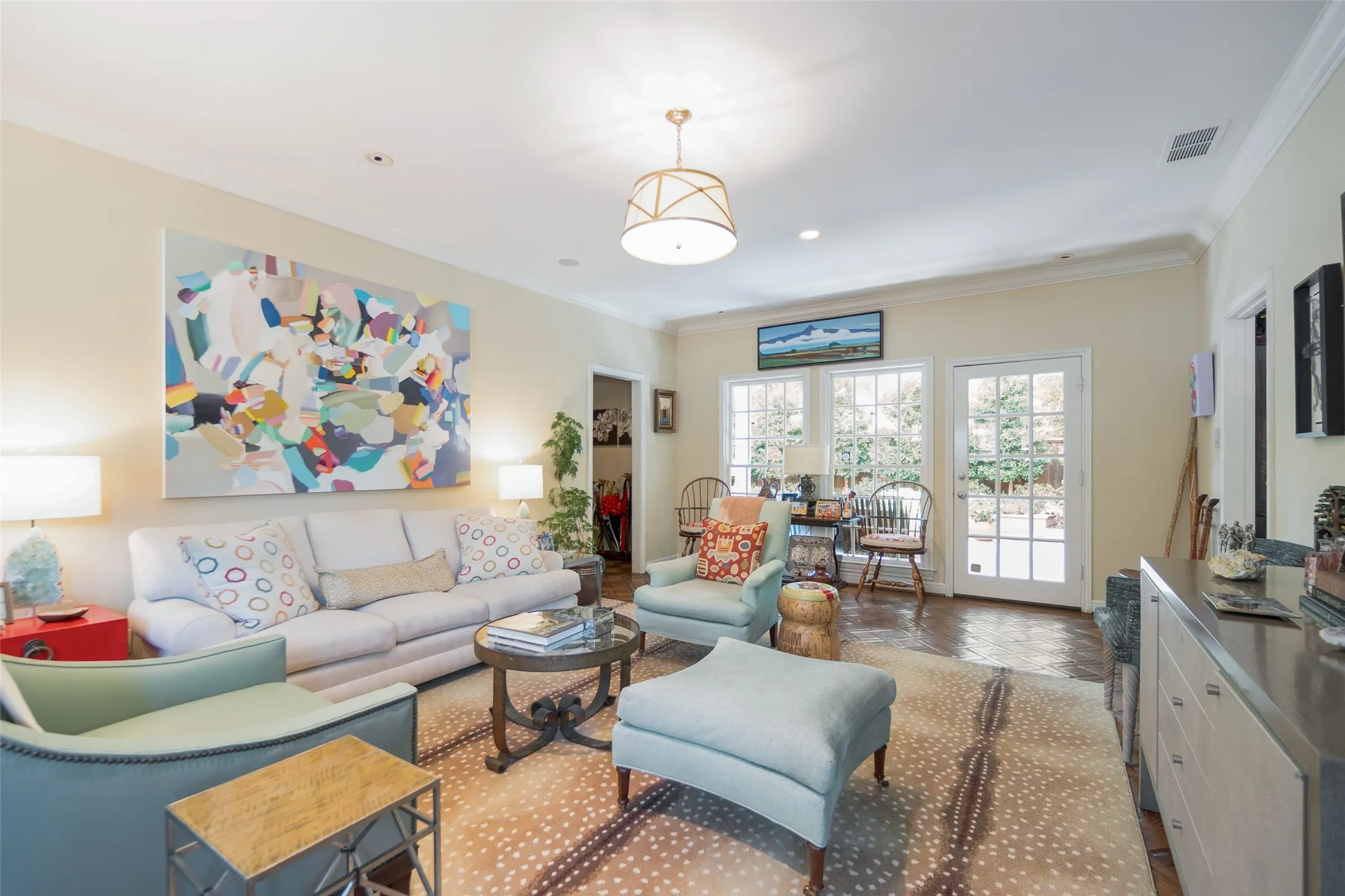 Recessed lighting, crown molding, double French doors, wood-finish flooring, and a decorative ceiling fixture