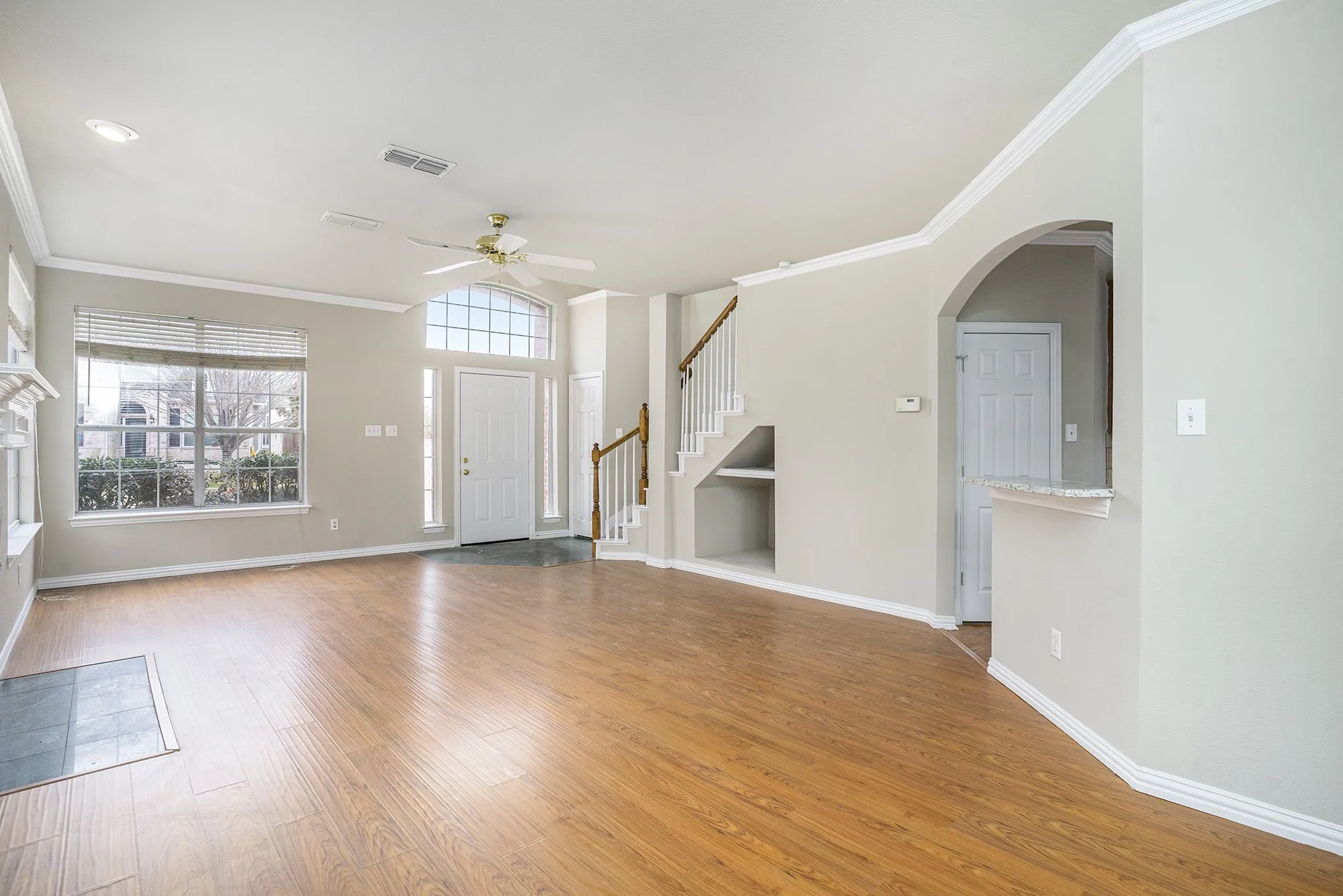 Unfurnished living room featuring crown molding, ceiling fan, and hardwood / wood-style floors