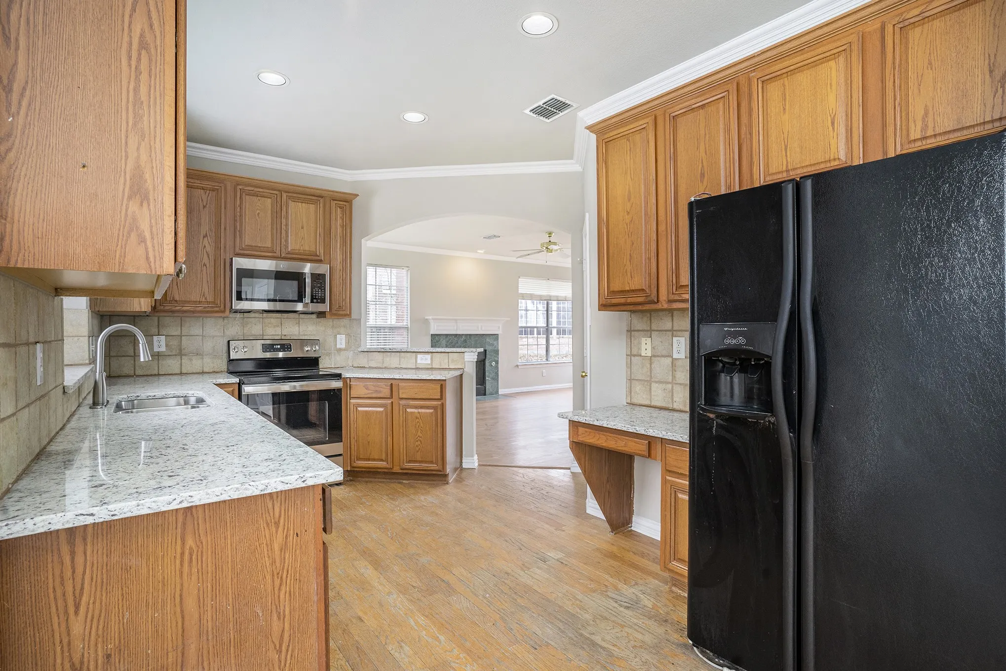 Kitchen featuring light hardwood / wood-style floors, stainless steel appliances, tasteful backsplash, crown molding, and sink