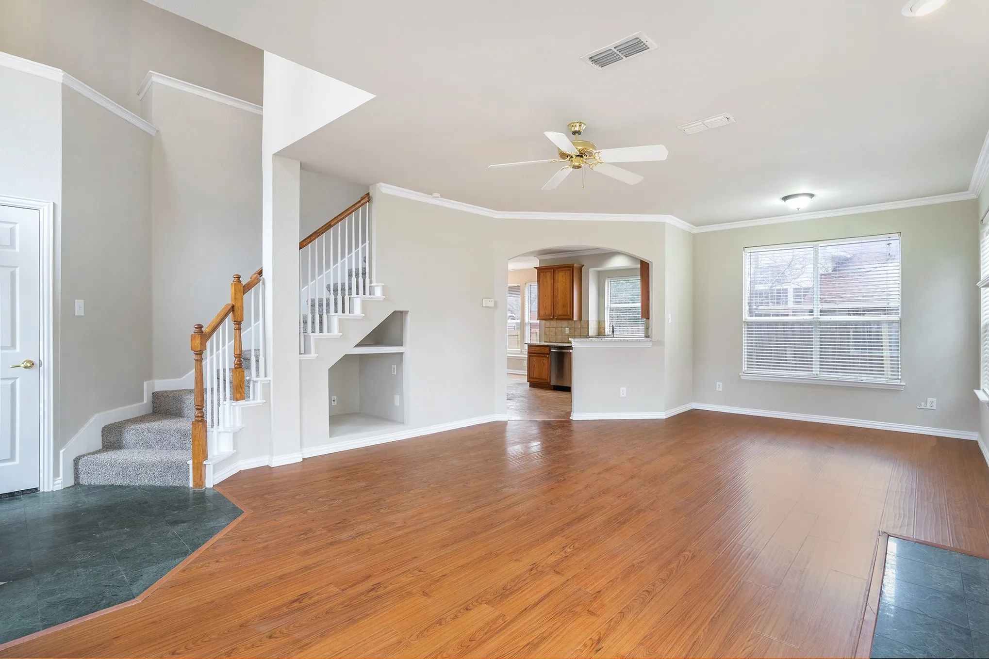Unfurnished living room featuring crown molding, hardwood / wood-style flooring, and ceiling fan