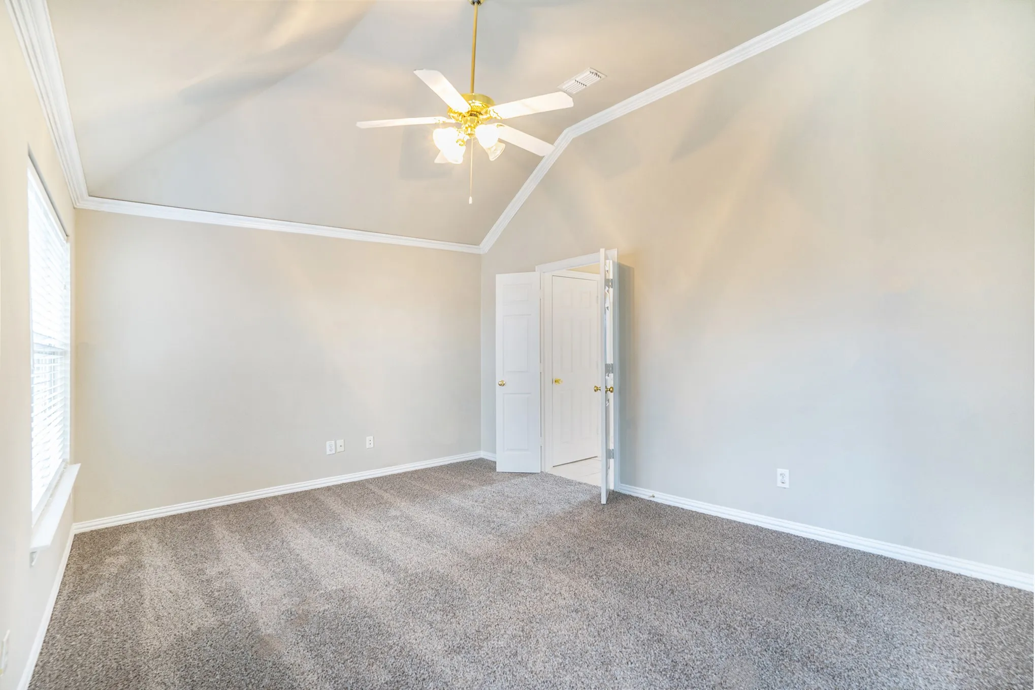 Unfurnished room with lofted ceiling, ceiling fan, carpet floors, and crown molding