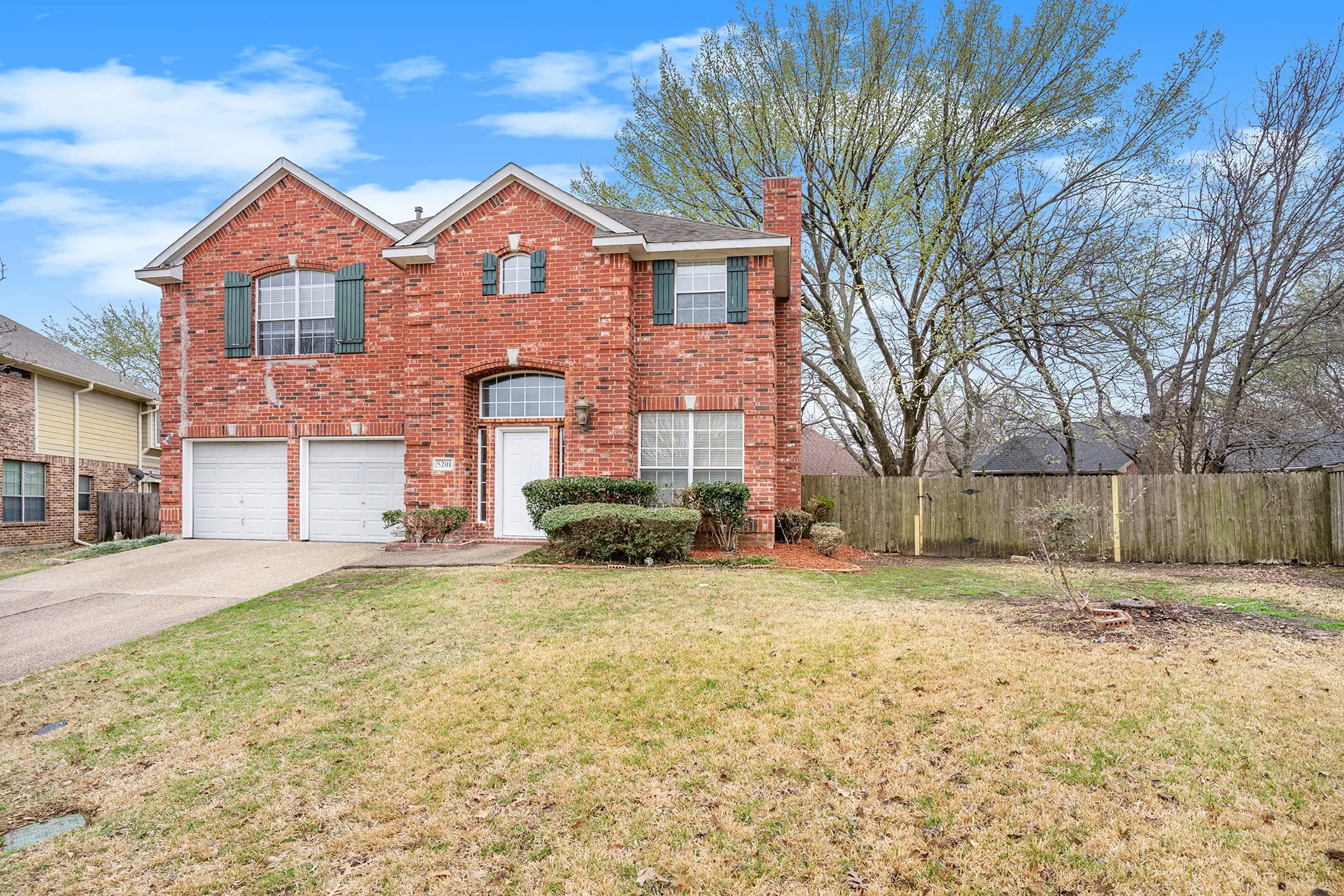 View of front of property featuring a garage and a front lawn