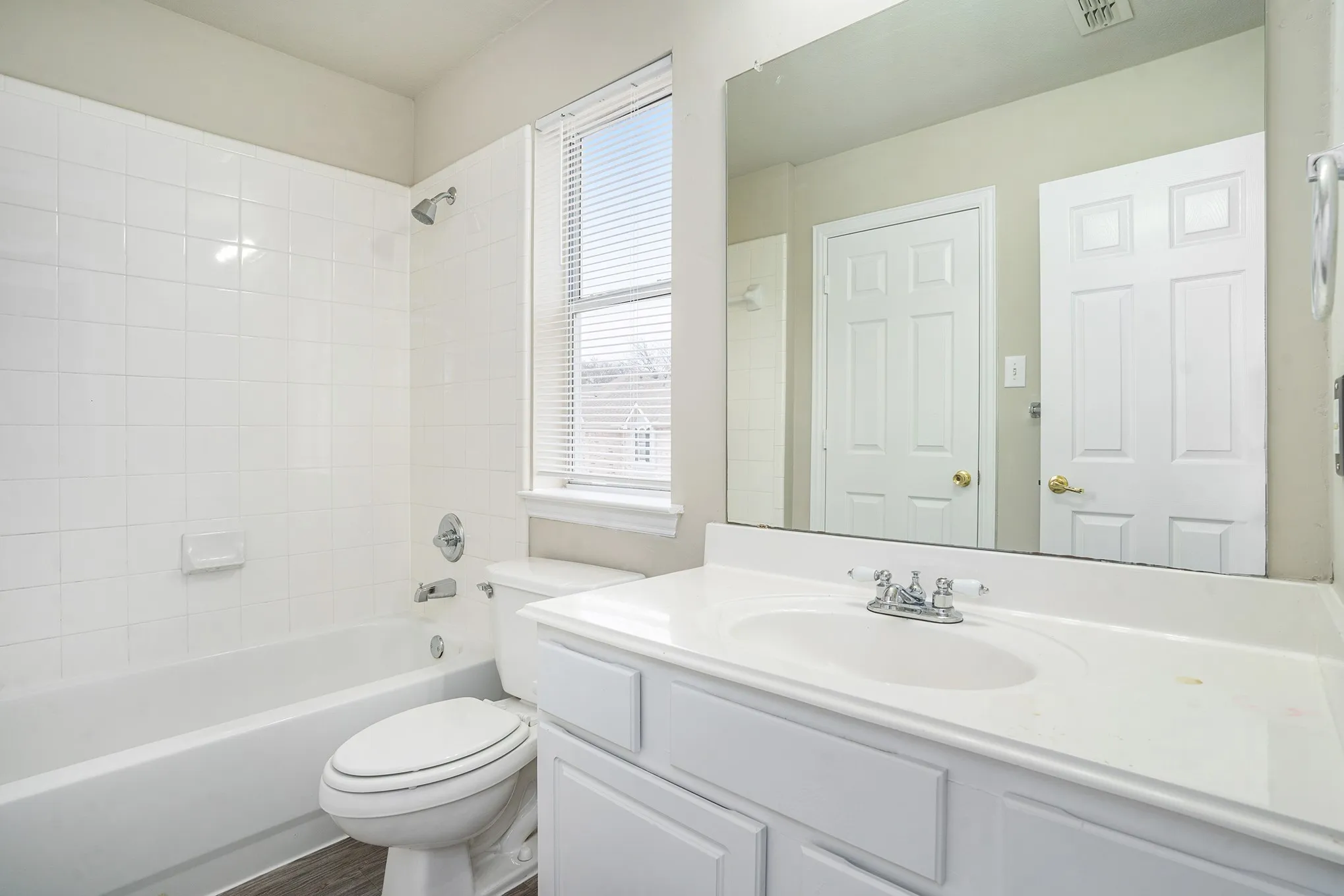 Full bathroom featuring a healthy amount of sunlight, vanity, toilet, and tiled shower / bath combo