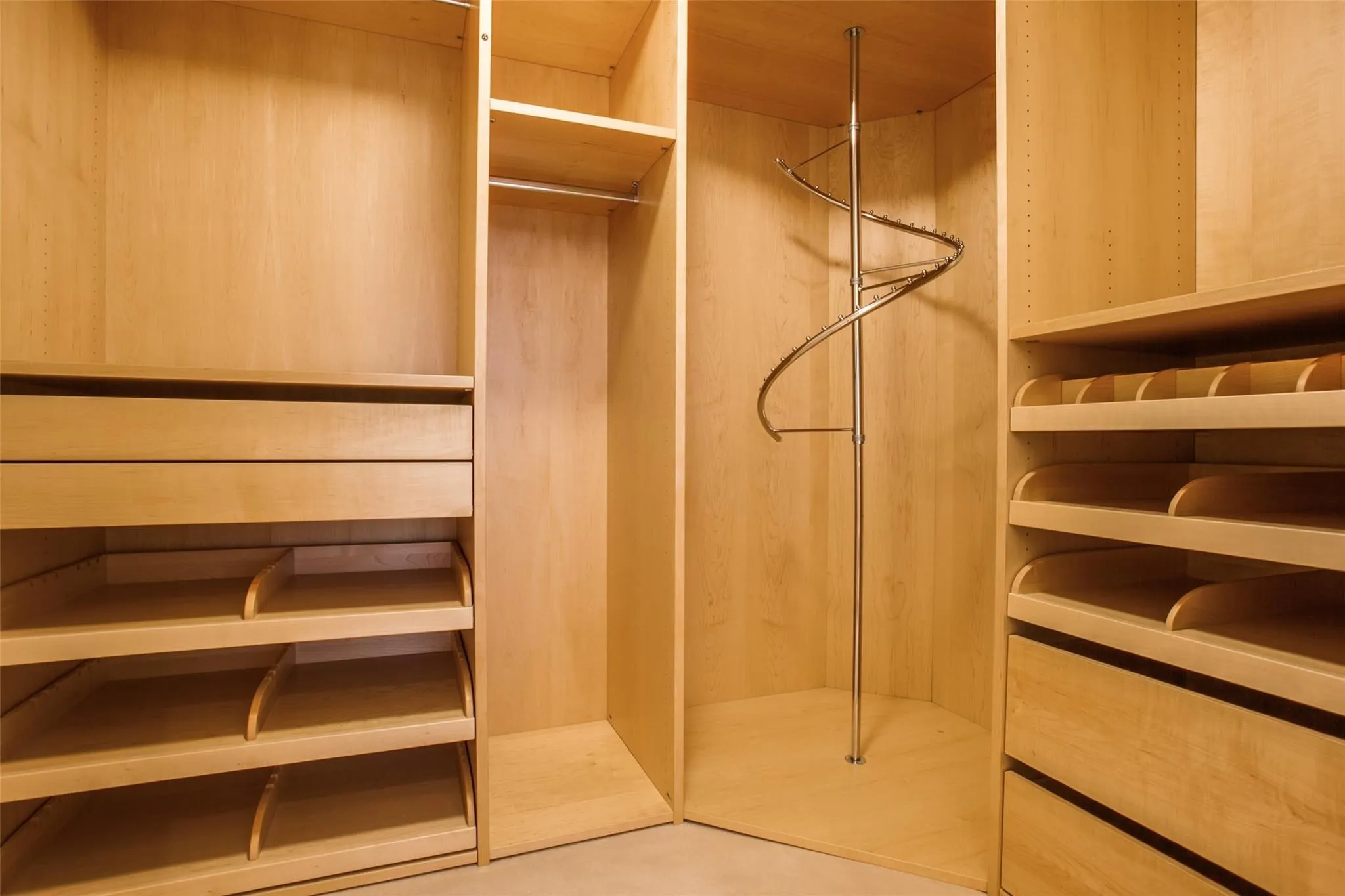 Custom closet system featuring light wood cabinetry