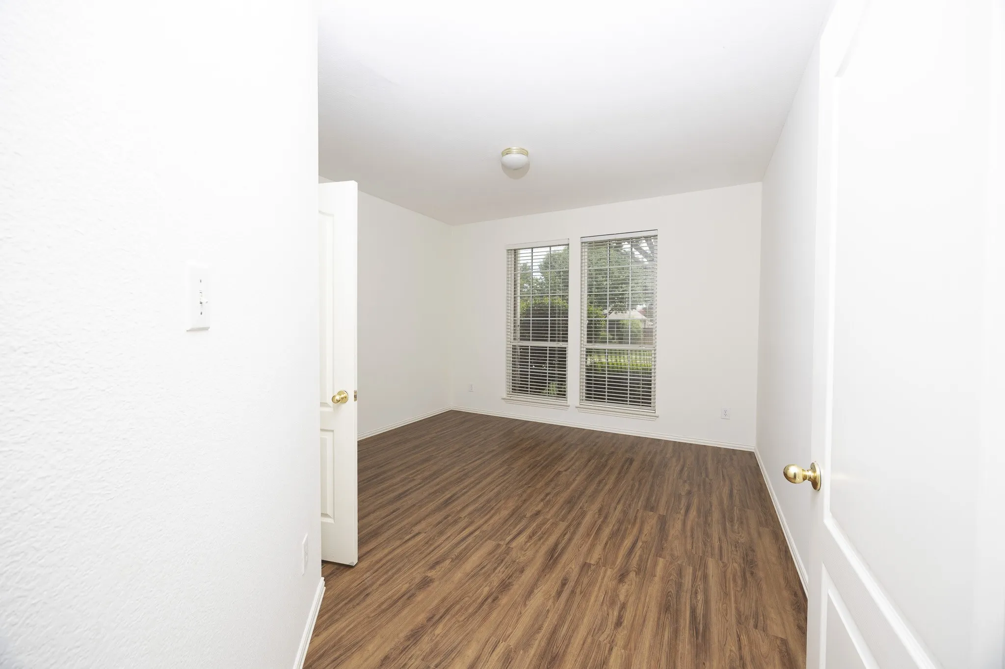 Empty room featuring dark wood-type flooring and baseboards