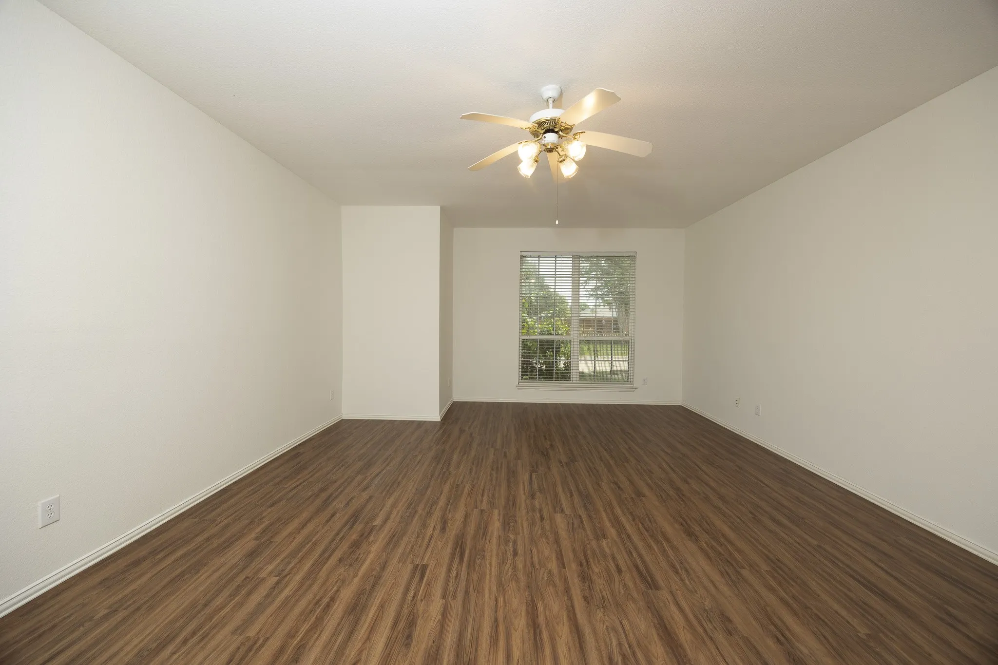 Empty room featuring dark wood-style floors and ceiling fan