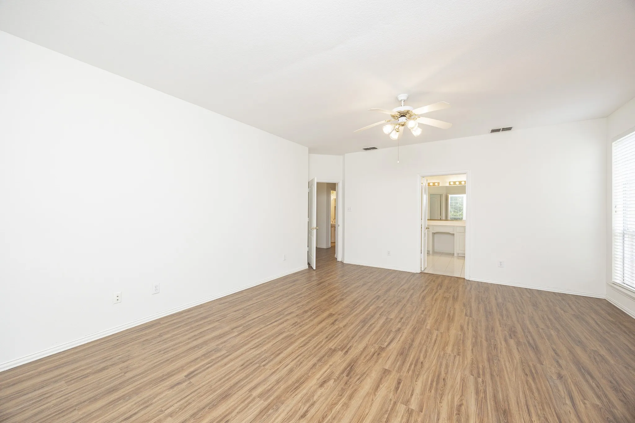 Empty room featuring light wood-type flooring and ceiling fan