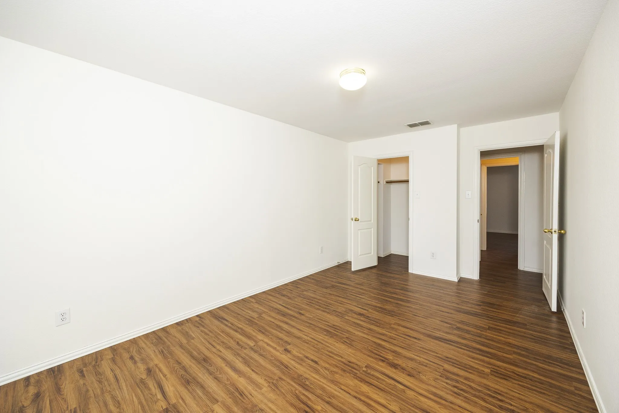 Unfurnished bedroom featuring dark wood-type flooring and baseboards
