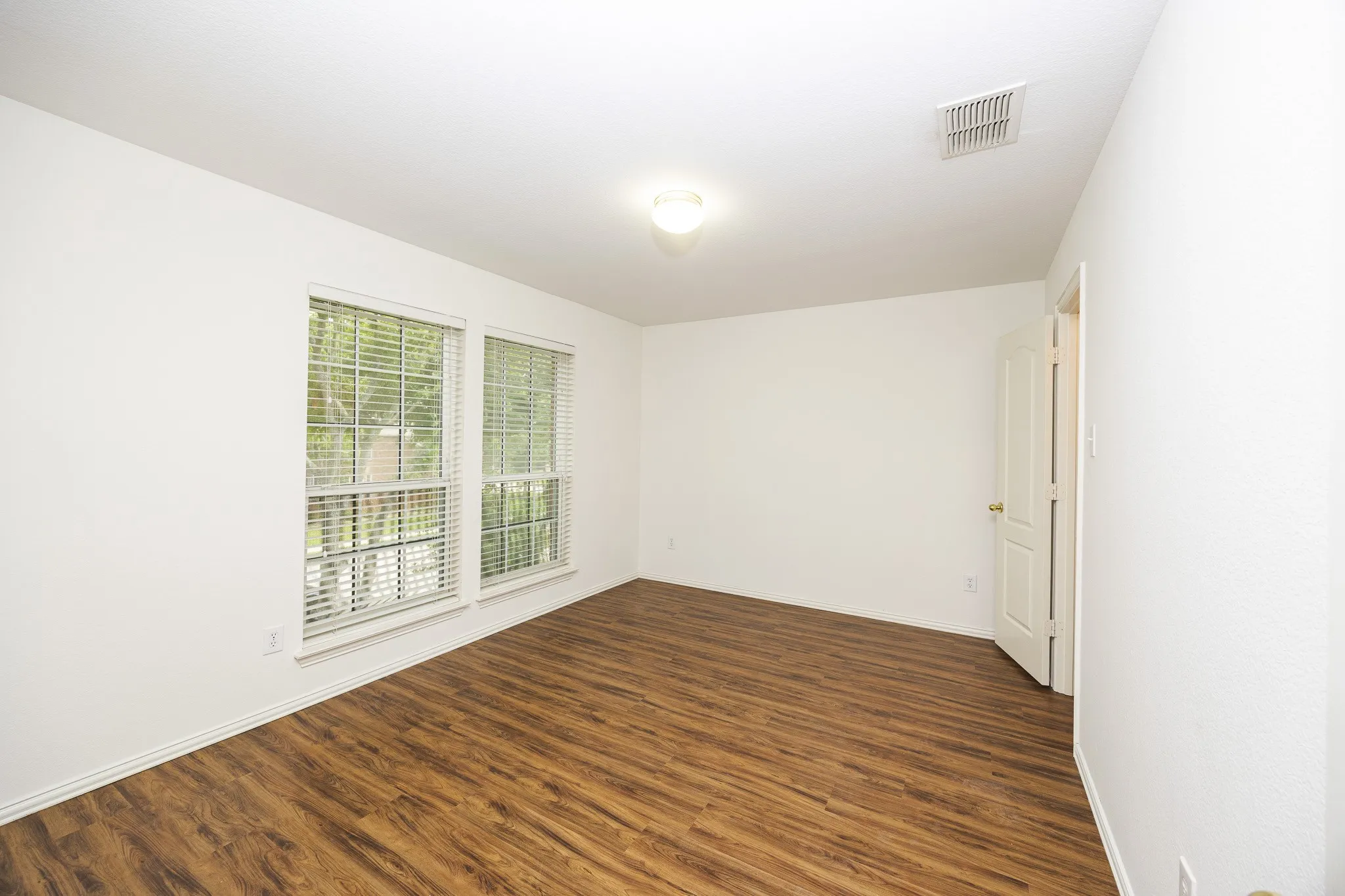 Spare room featuring dark wood-type flooring