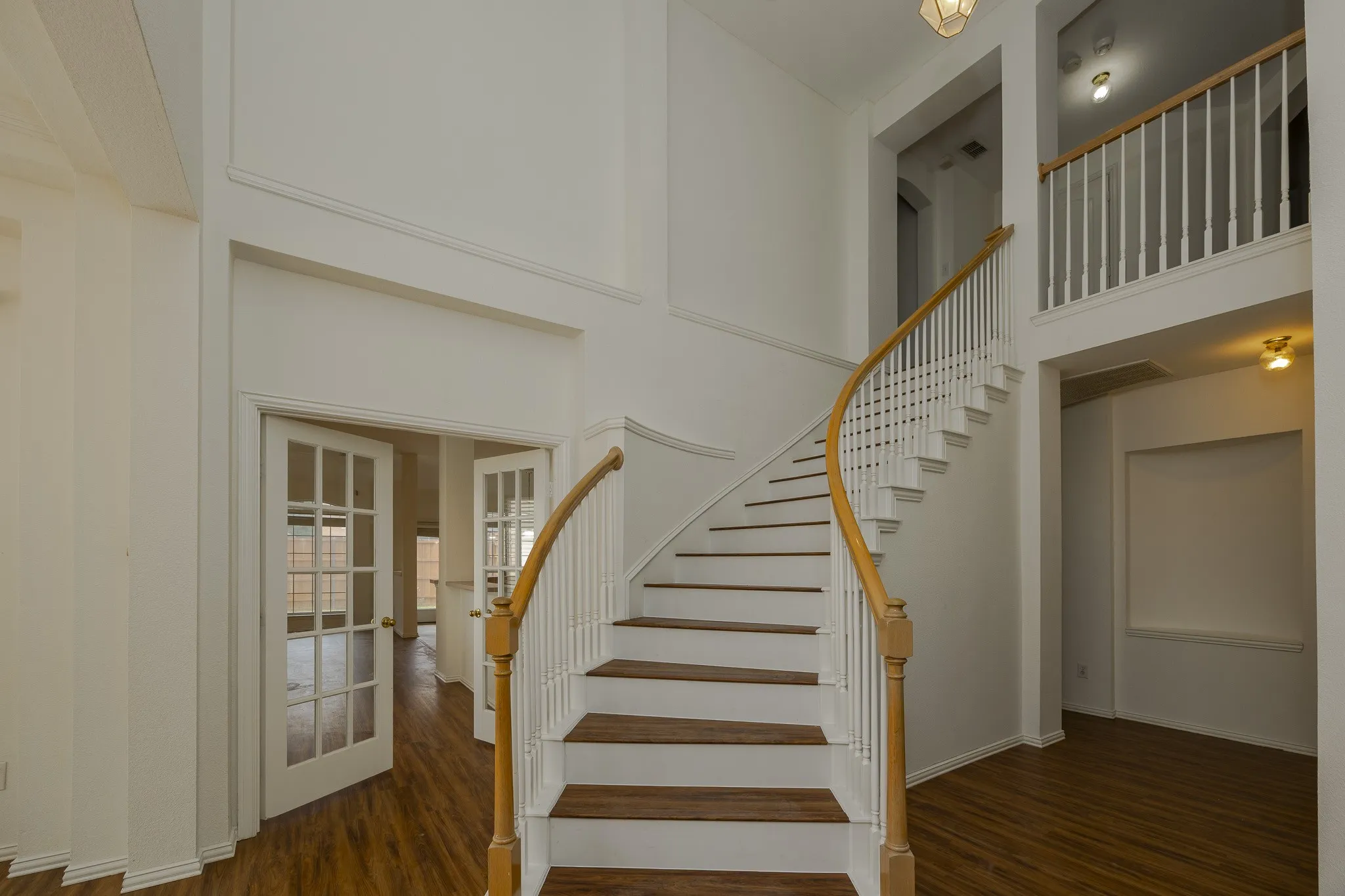 Staircase with a high ceiling and wood finished floors