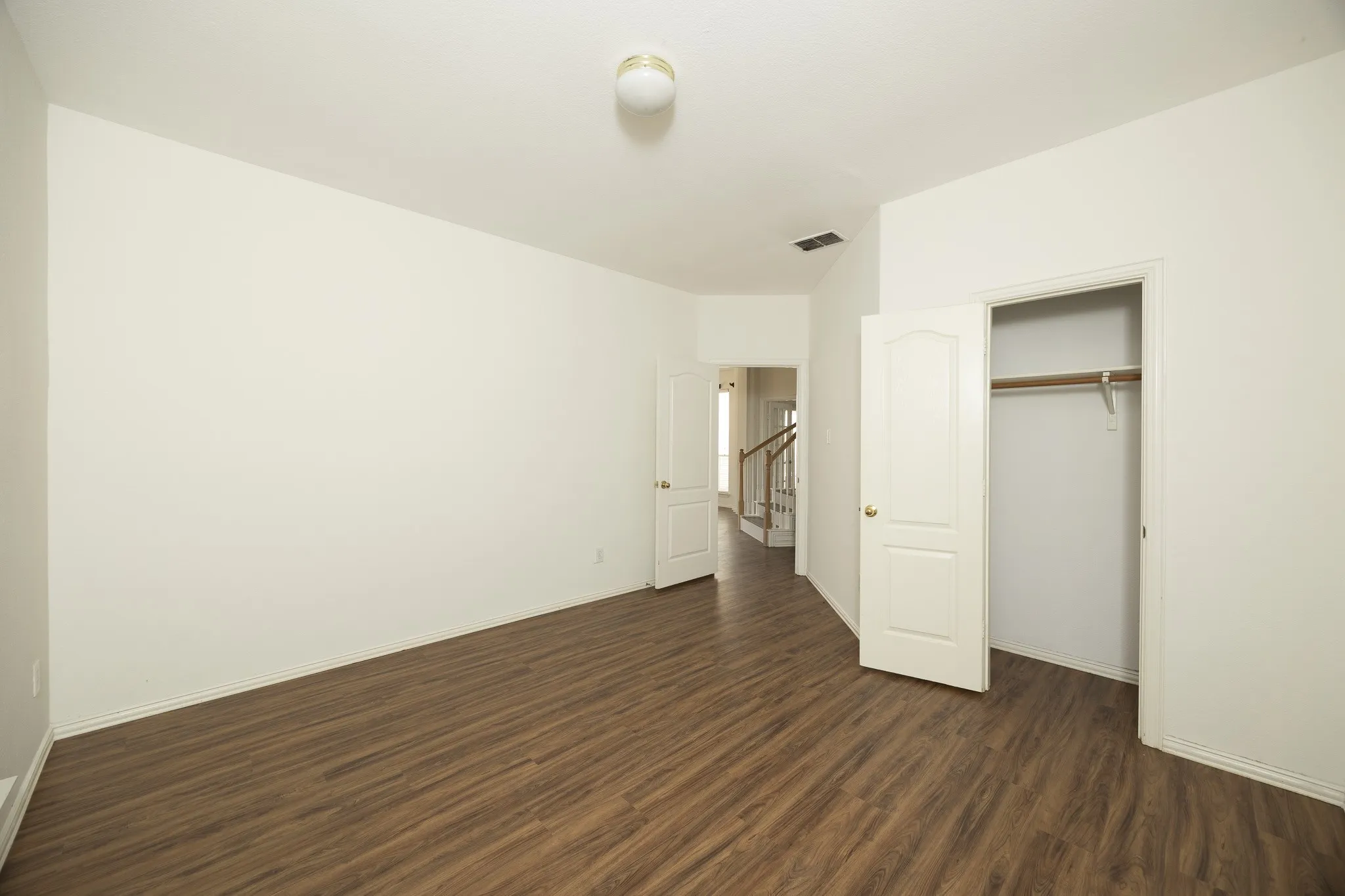 Unfurnished bedroom featuring dark wood-type flooring and a closet