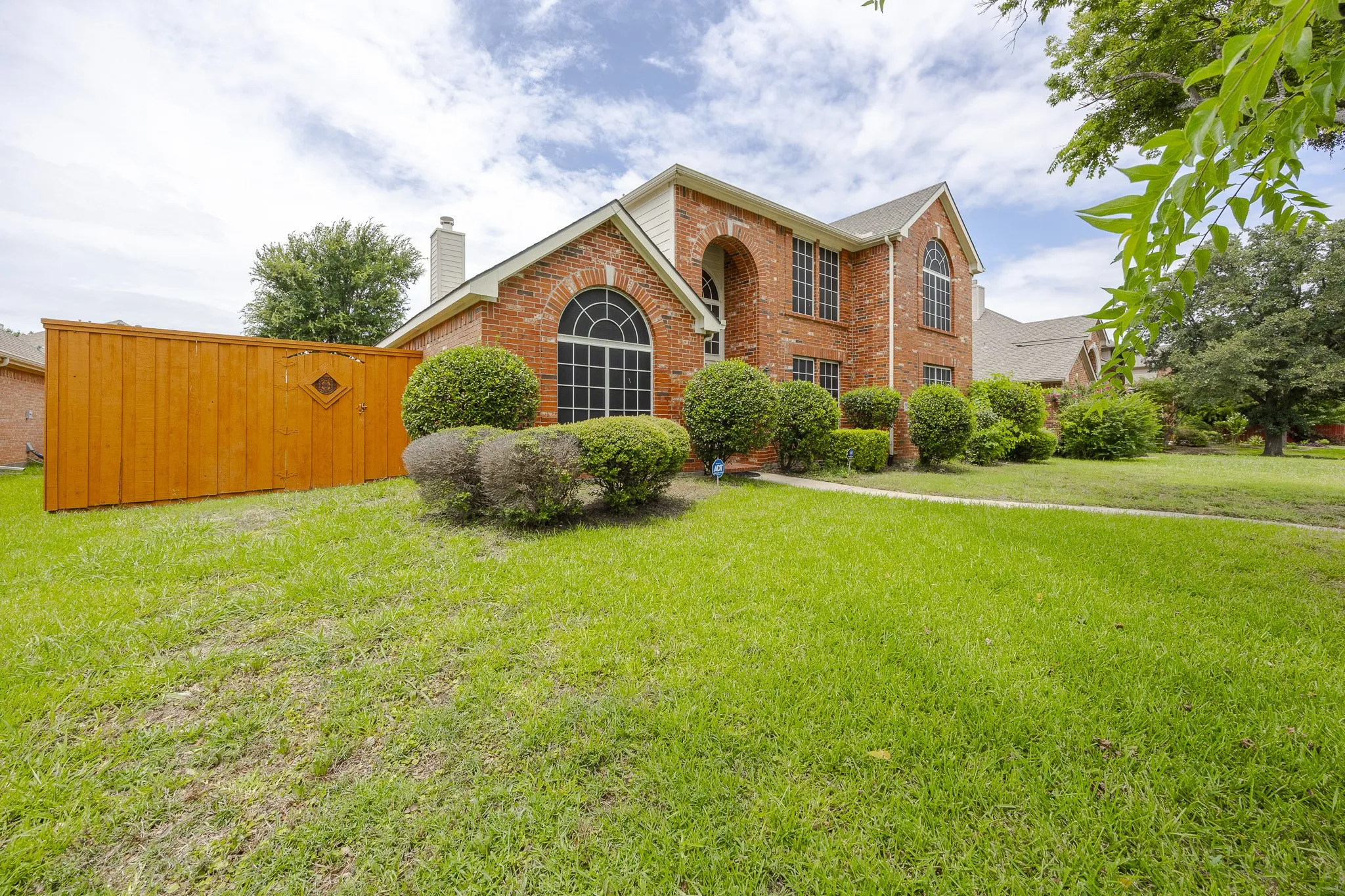 View of front of property with brick siding, a front lawn, and a chimney