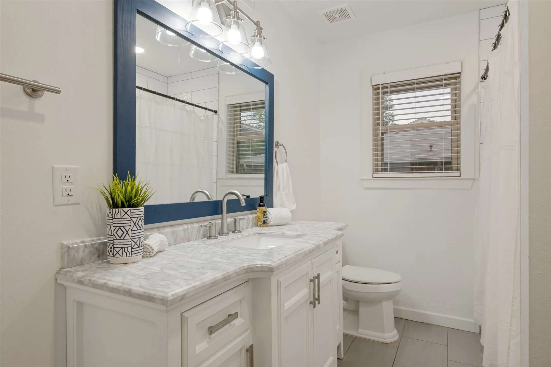 Guest Bath located in hallway to right of the living room. Sleek 24 x 12" light colored tiles with shower/tub and upgraded vanity.
