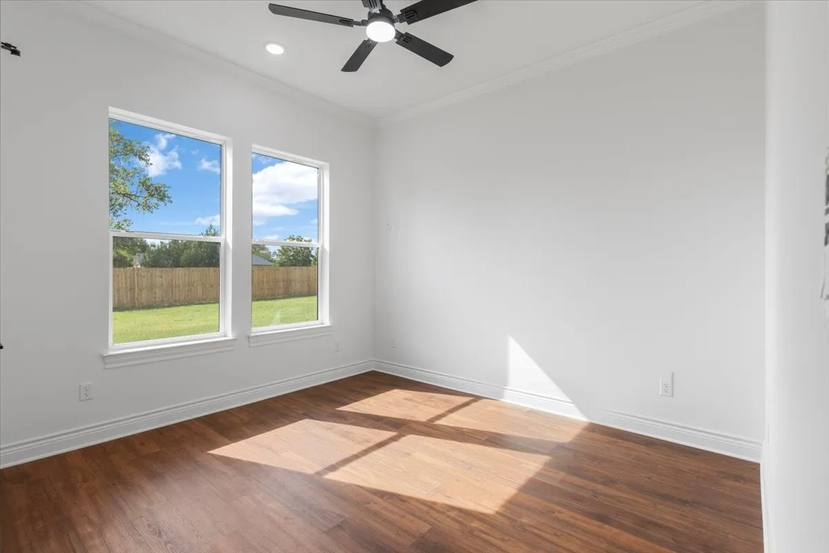 Bright interior with two double-hung windows, wood-finish flooring, a ceiling fan, and recessed lighting