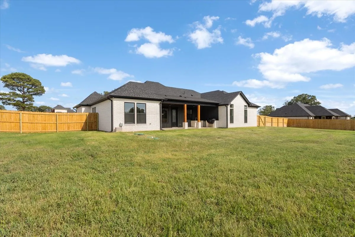 Expansive grassy yard with a full privacy fence