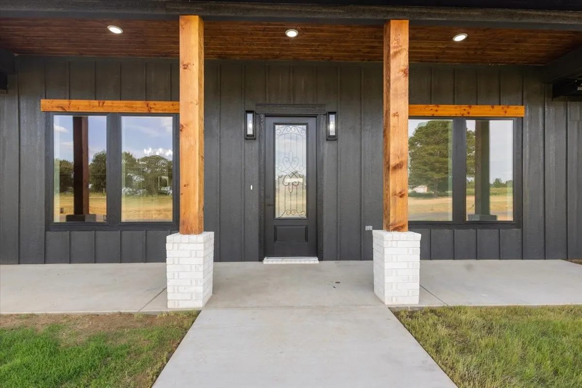 Board and batten exterior with wood columns and white brick bases