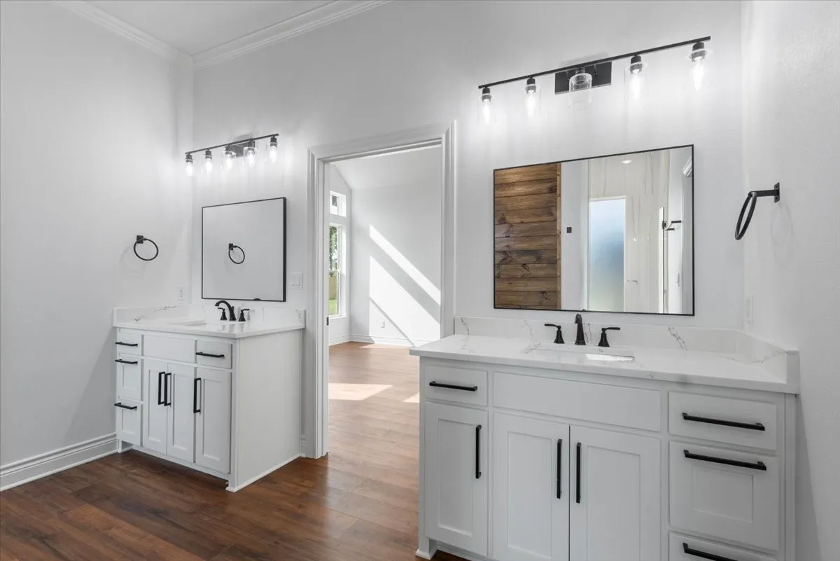 Dual vanities with white cabinetry, white countertops, and matte black fixtures