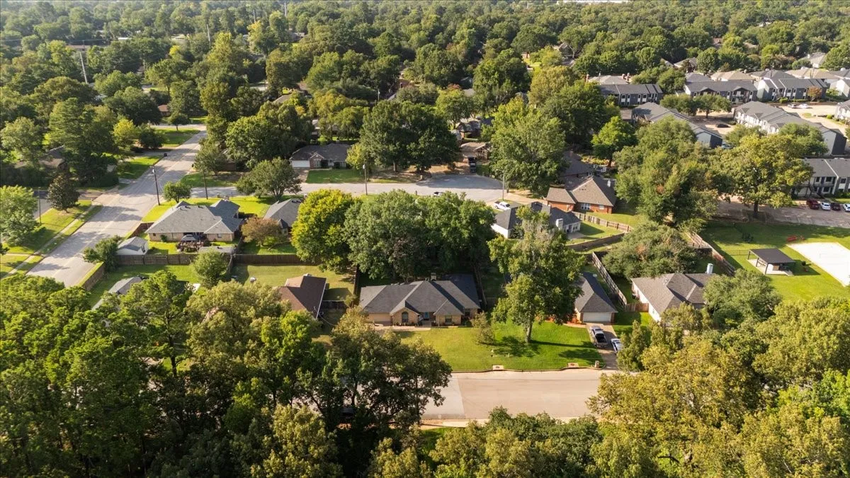 Aerial perspective showcasing a residential neighborhood with mature trees