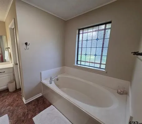 Soaking tub with an integrated deck, detailed privacy window, and wood-finish flooring