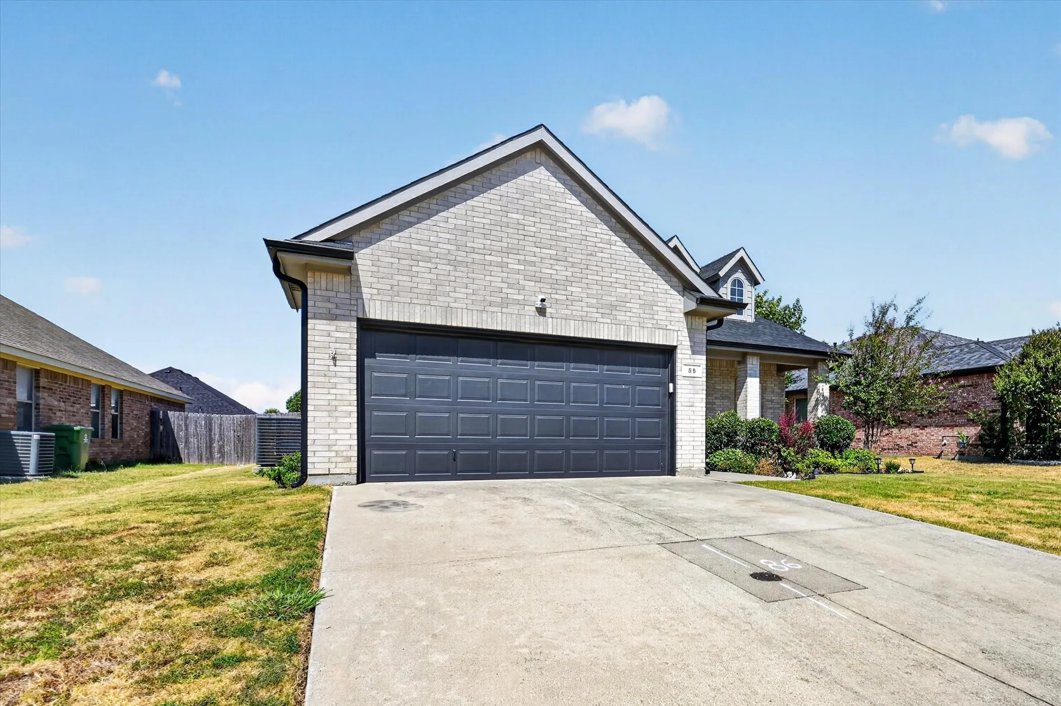 Concrete driveway leading to a two-car garage with a paneled door