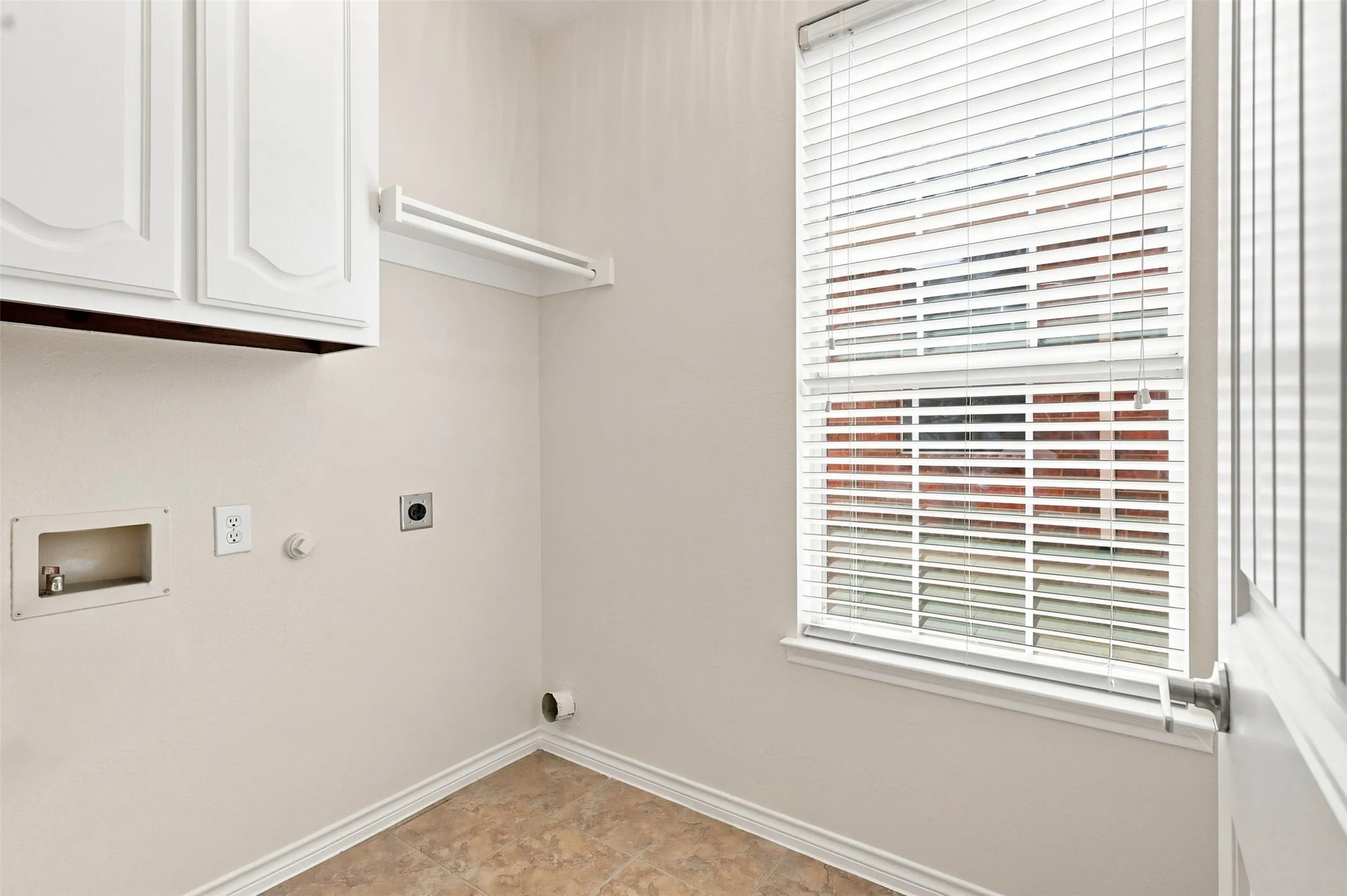 Laundry room has upper cabinets for storage