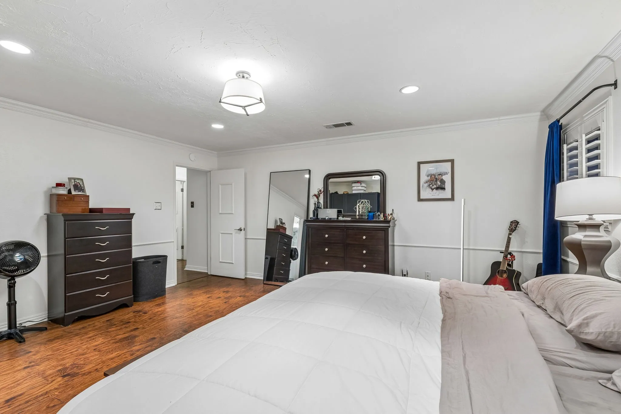 Bedroom featuring dark wood finished floors, ornamental molding, and recessed lighting