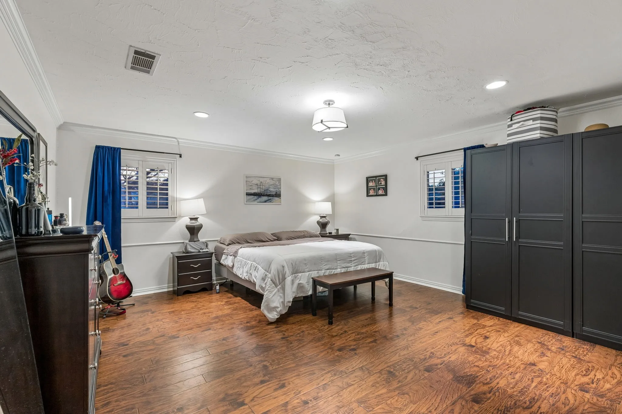 Bedroom featuring dark wood-style floors and crown molding