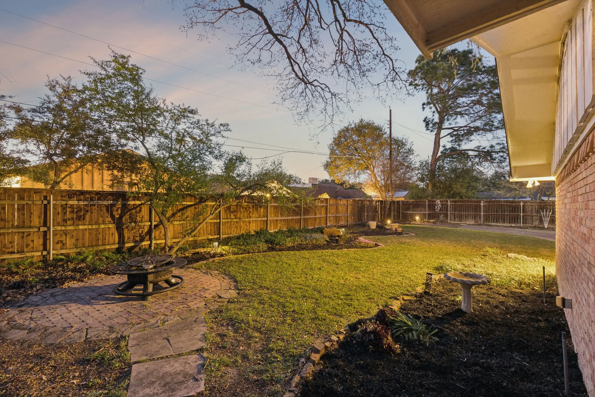 Fenced backyard with a patio and a fire pit