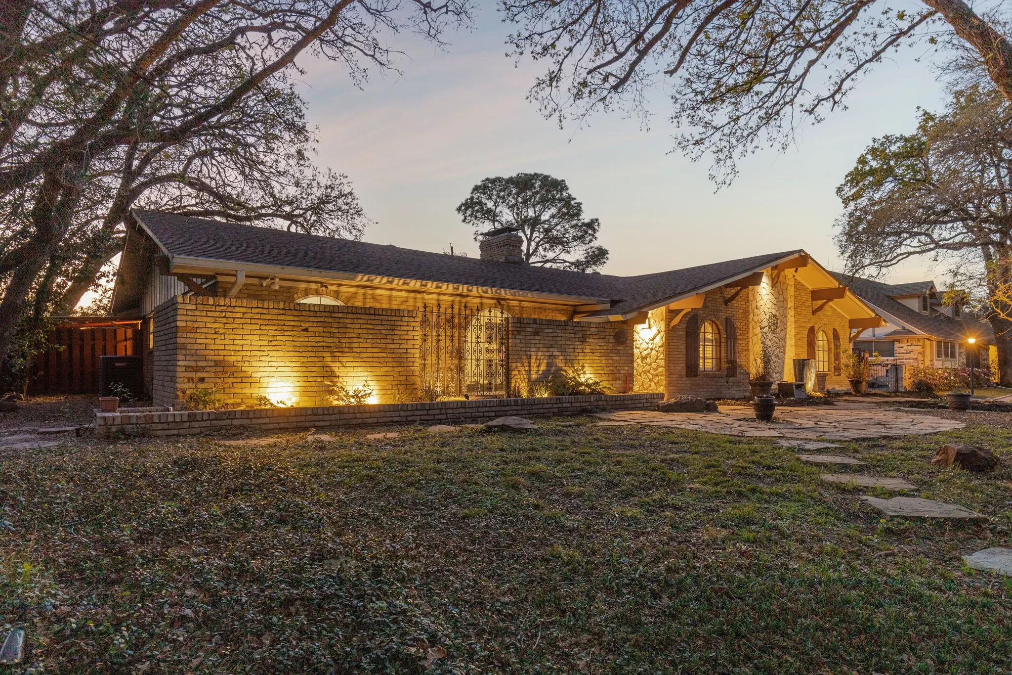 View of front of house featuring brick siding and a chimney