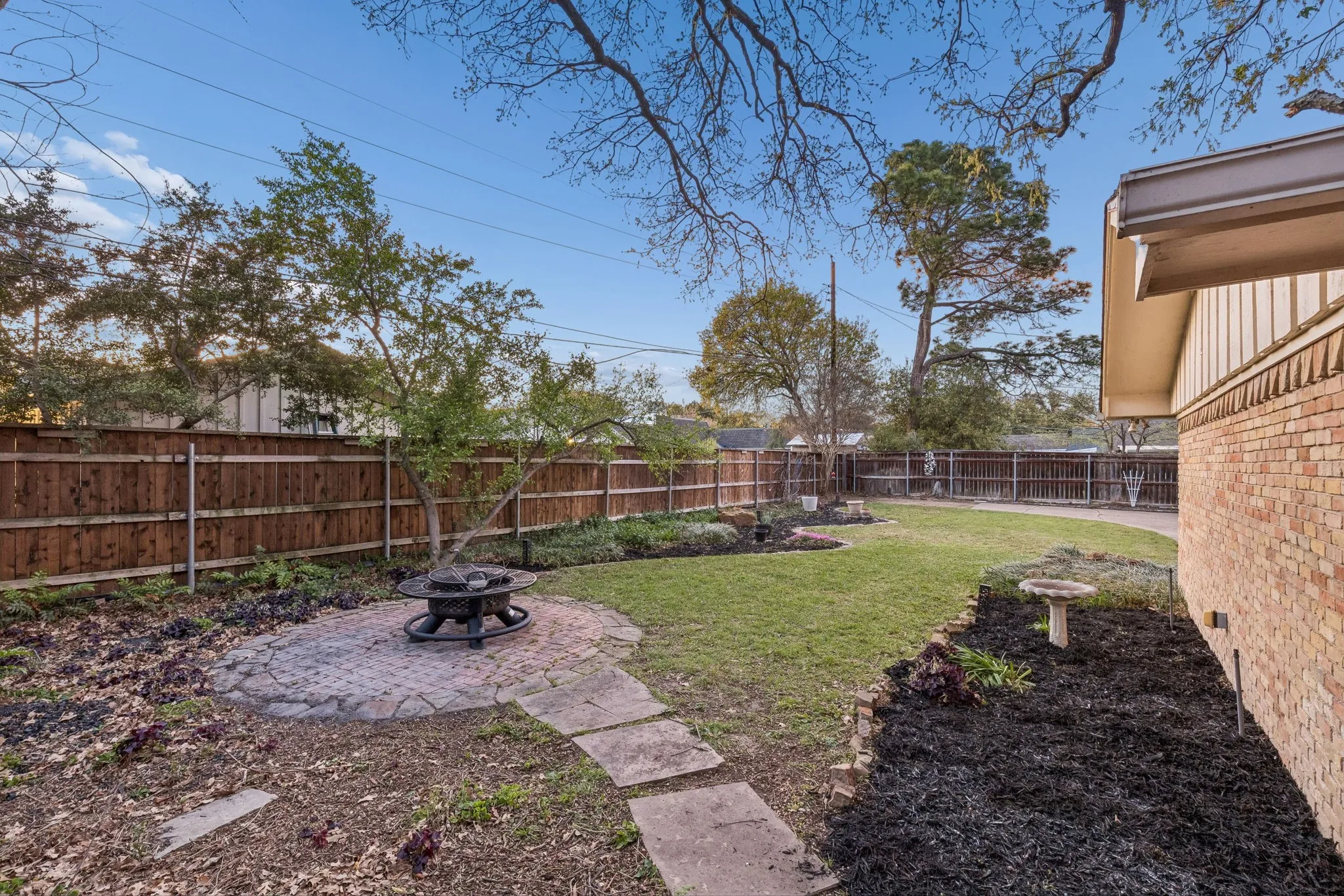 Fenced backyard with a patio area and an outdoor fire pit