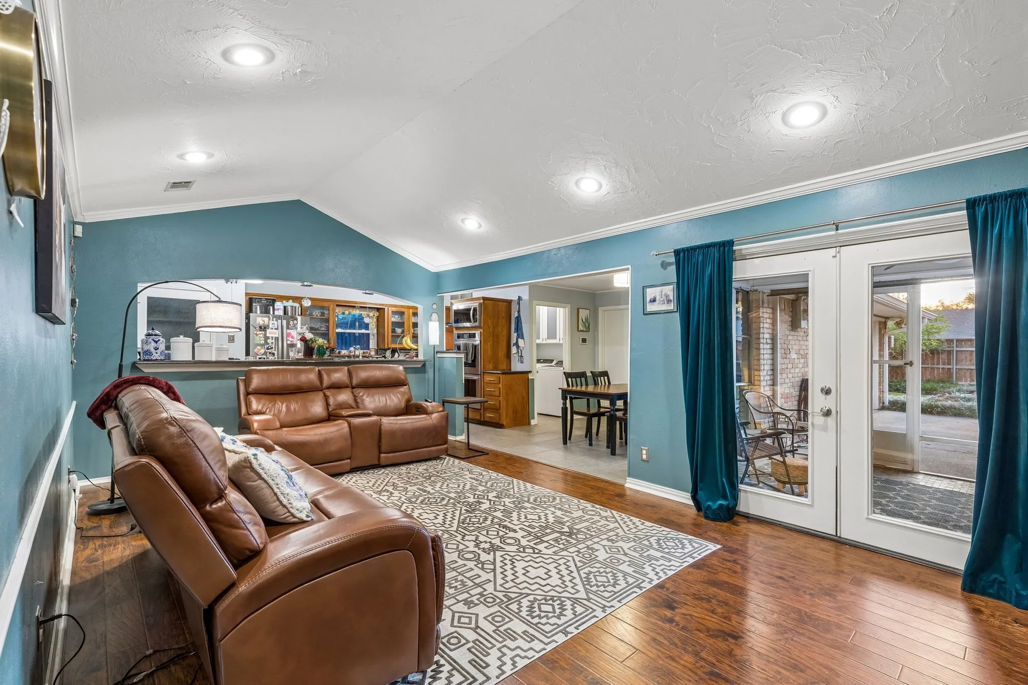 Living area with ornamental molding, hardwood / wood-style floors, a textured ceiling, and french doors